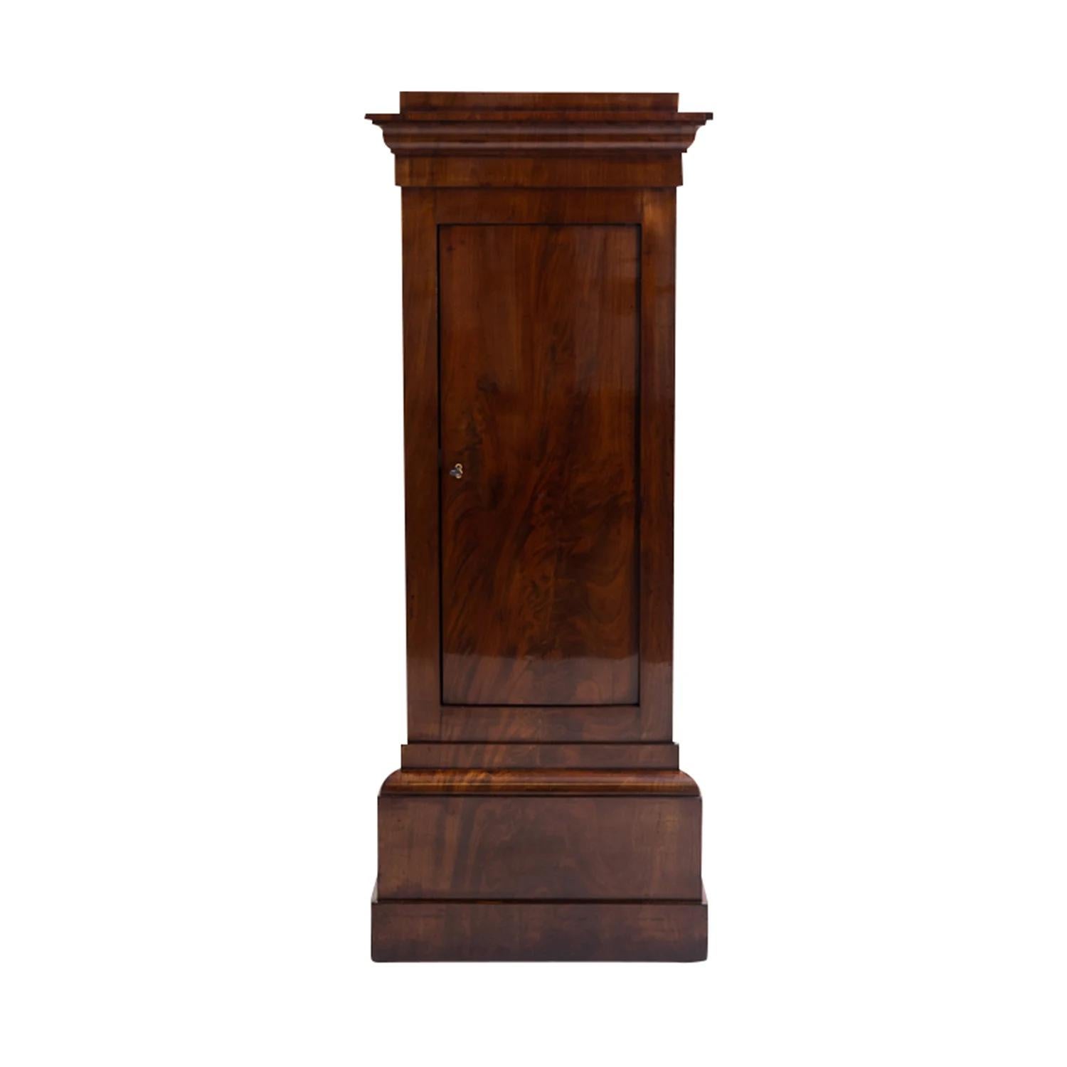 A dark-brown, antique German early Biedermeier pair of pedestals made of hand shellac polished Mahogany, in very good condition. Each of the detailed podiums are composed with three shelving, consisting its original brass hardware and keys,