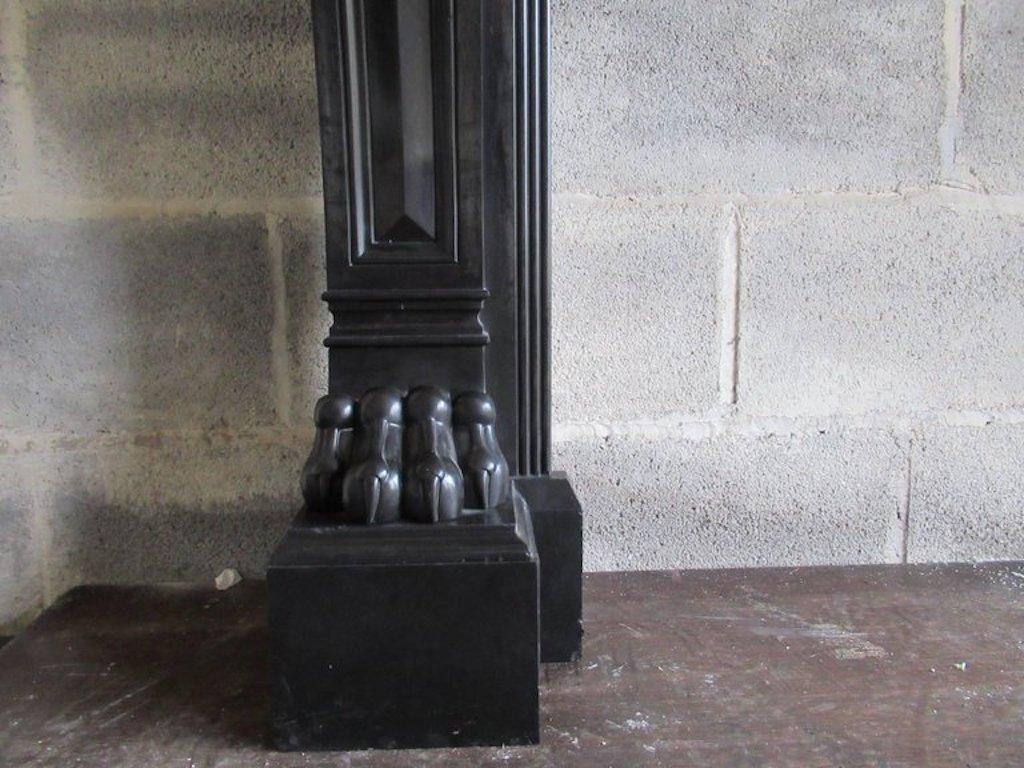 A 19 century (dated 1813) French black Napoleon marble fireplace with panelled freeze and corner blocks on scrolled legs with acanthus leaf terminating on impressive lion paw supports.