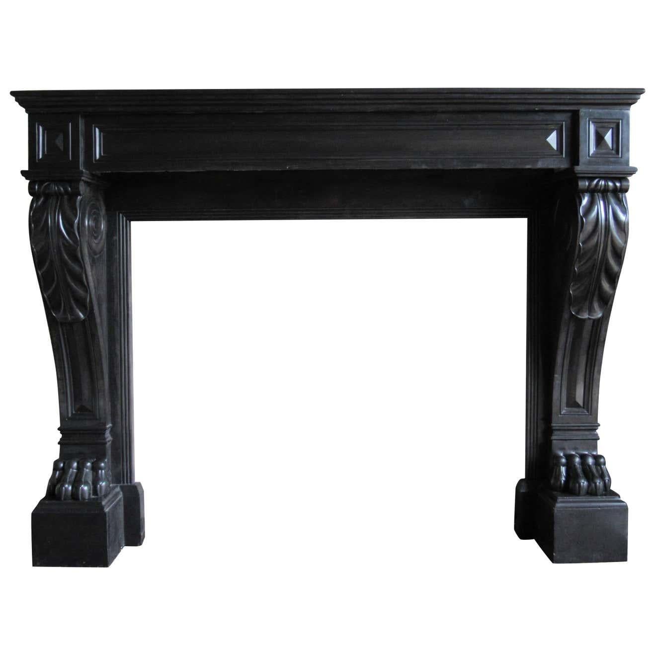 A 19th century (dated 1813) French black Napoleon marble fireplace with panelled freeze and corner blocks on scrolled legs with acanthus leaf terminating on impressive lion paw supports.