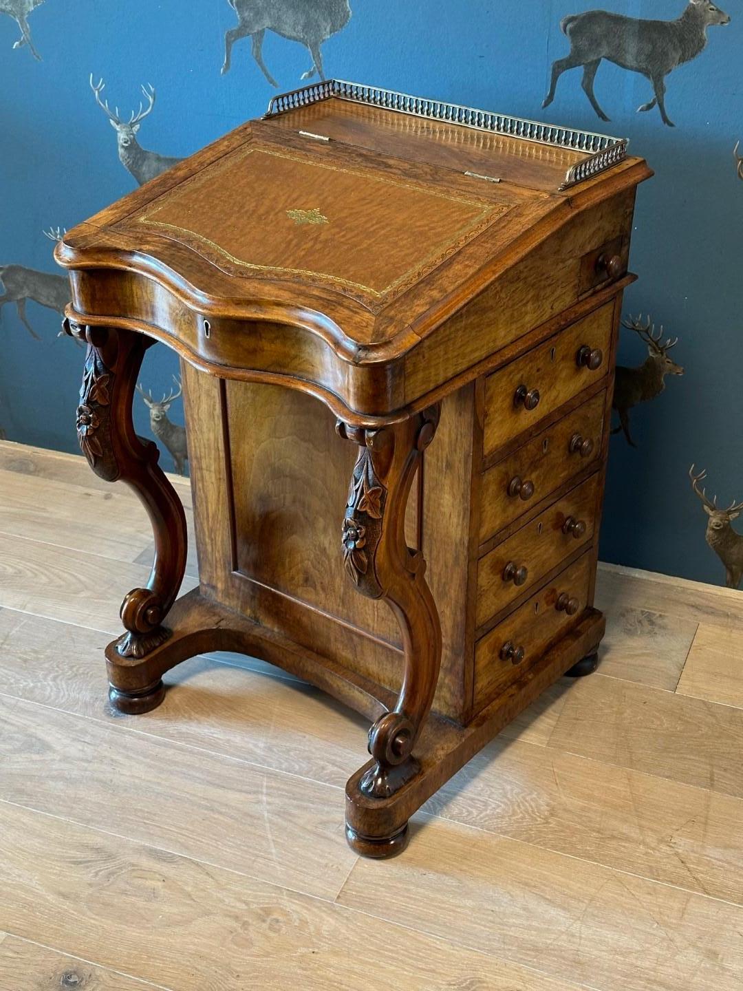 Bellissimo scrittoio antico Davenport in radica di noce. Intarsio in pelle marrone chiaro con profili dorati. Sotto la superficie di scrittura si trovano 1 cassetto piccolo e 2 falsi frontali di cassetti.  Sul lato destro ci sono 4 cassetti con