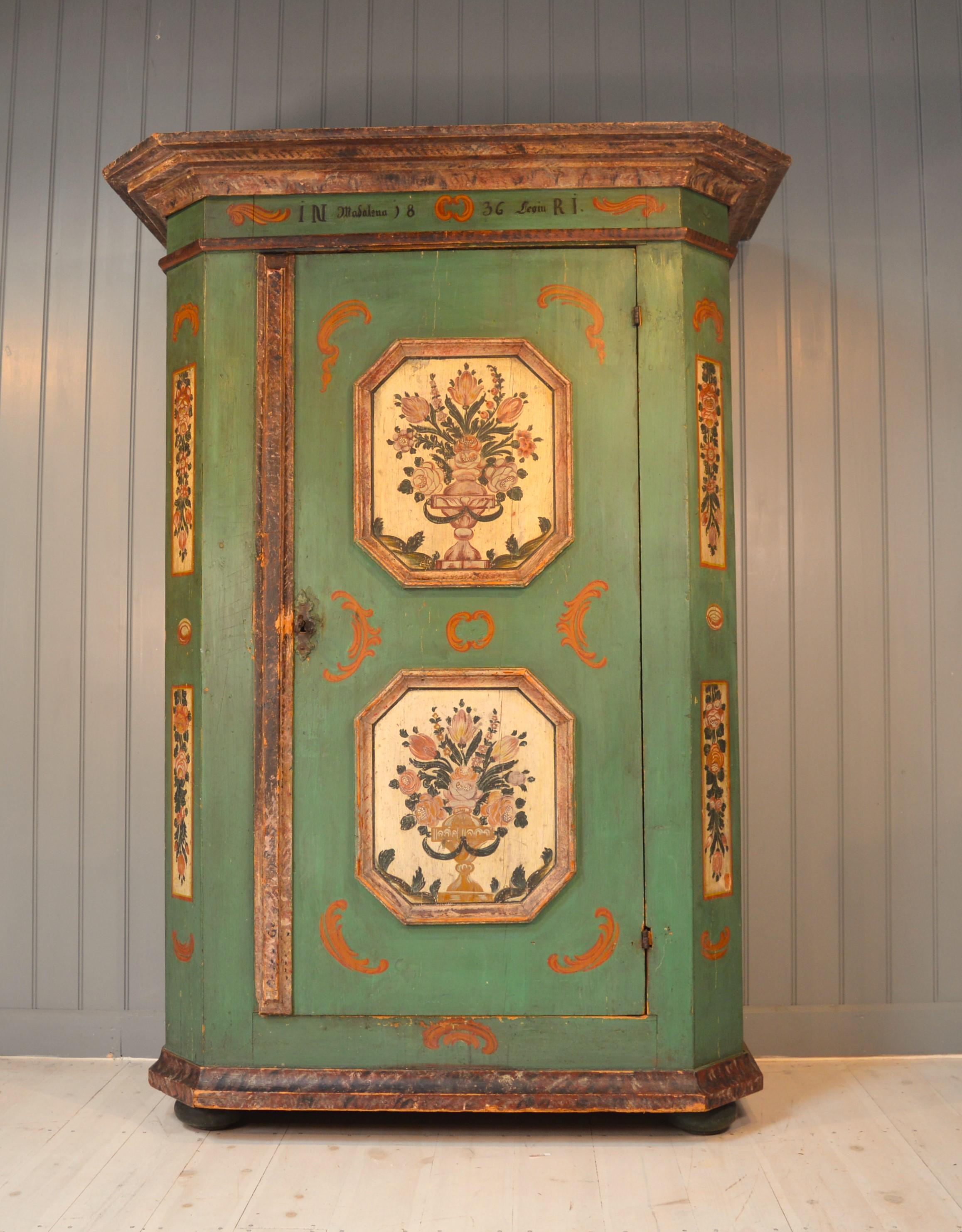 Here we have a very good painted cupboard in untouched condition in original green paint ,with floral panels very typical of the area. The cupboard originates from the Tyrol and has its original hinges lock and key and turned feet. It has a