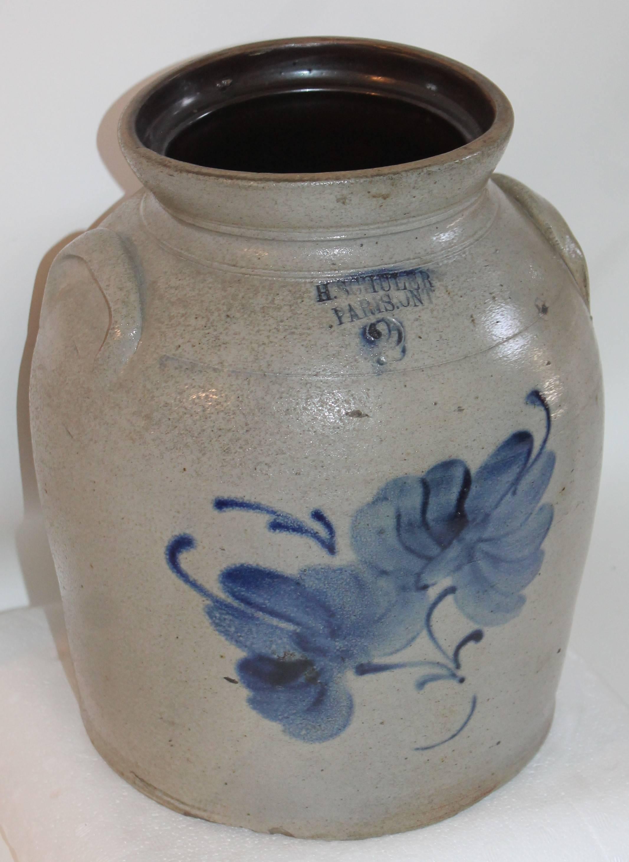 This fine Folk Art pottery crock has heavy blue decorated salt glaze. The condition is very good. It is signed H.SCHULER PARIS,ONT .... CANADA with a blue two and large floral decoration. It is double handled as well. The is a minor glaze chip on
