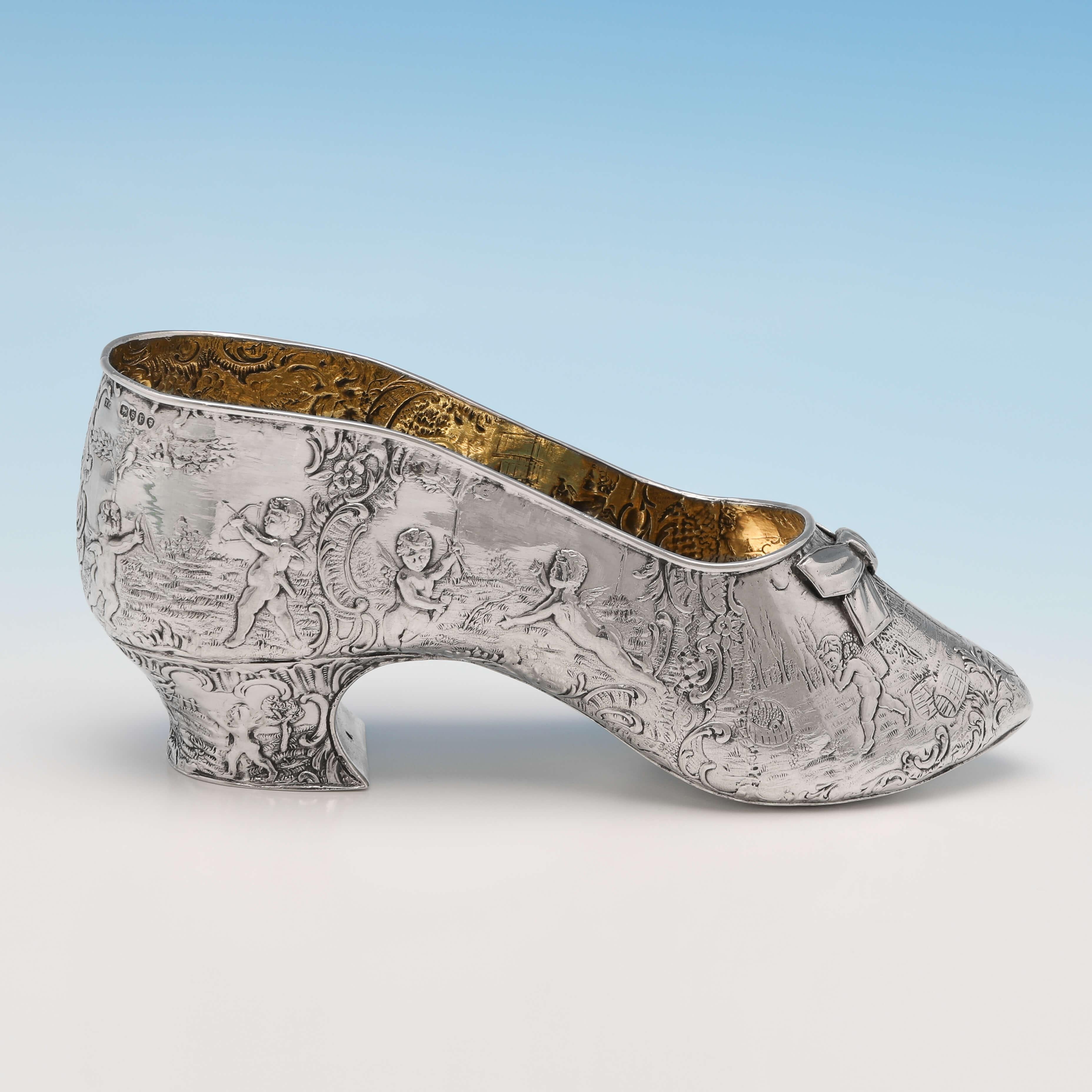 Import marked for London in 1893 by Thomas Glaser, this attractive, Antique Sterling Silver Model of a Shoe, features chased decoration throughout, and a gilt interior. The show model measures 2.75