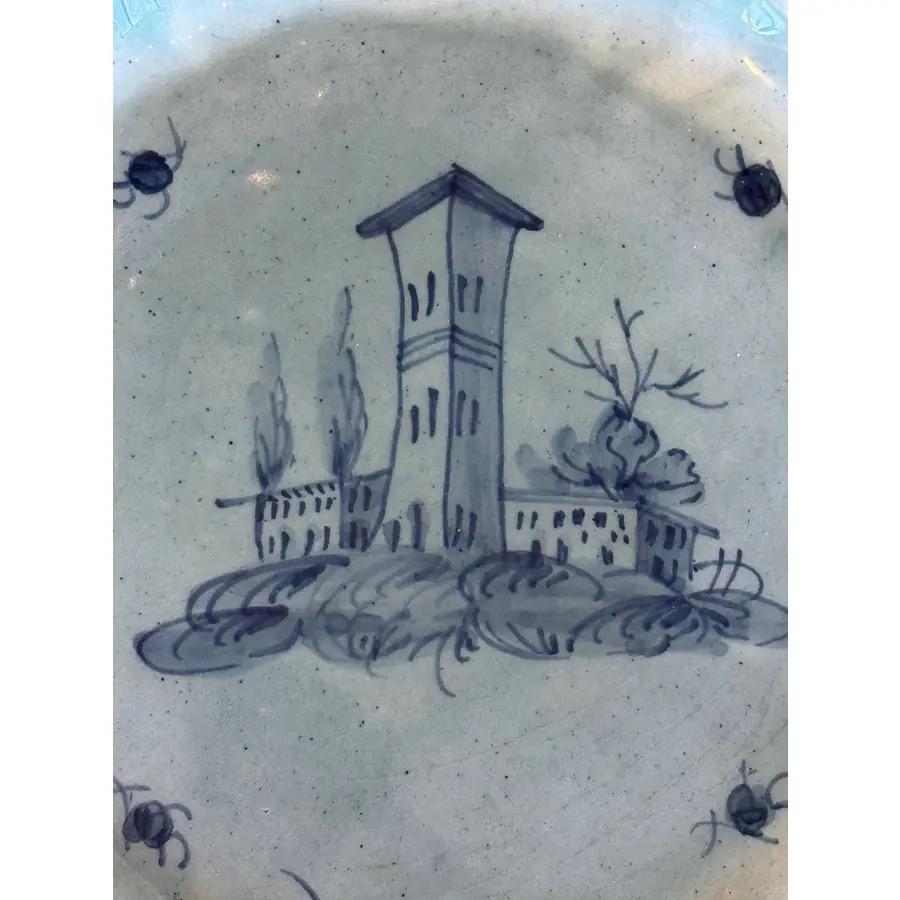 Un plato de loza azul y blanca. Una escena en una torre.