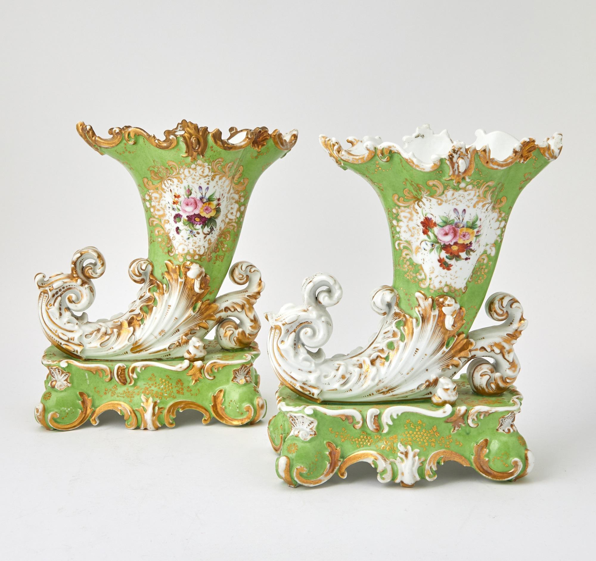 Questa elegante coppia di vasi decorativi della metà del XX secolo, opera del rinomato Jacob Petite, mette in mostra la bellezza senza tempo della porcellana francese. Ogni vaso è realizzato in un'unica forma a cornucopia, appoggiata con grazia su