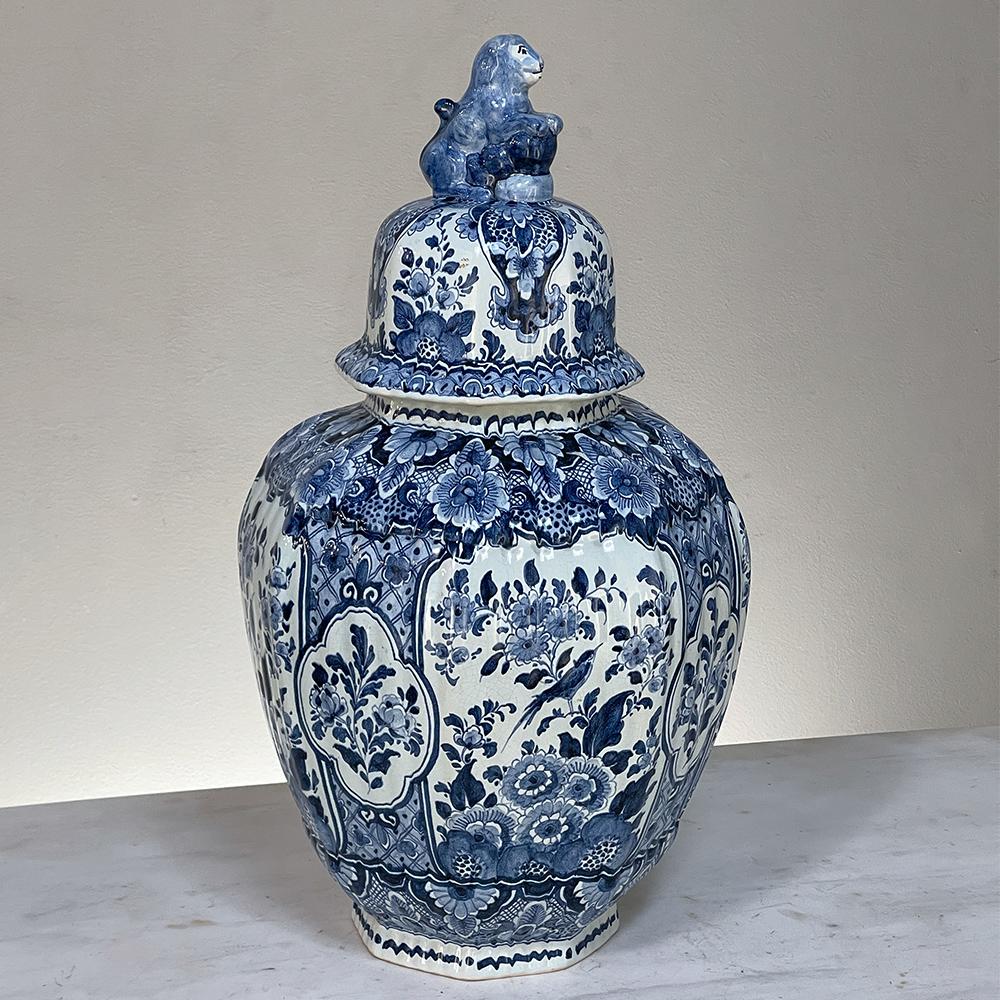 19th Century delft hand-painted blue & white lidded urn is a fine example of the intricately adorned porcelains from the Delft region in Holland produced during the 1800s. The classic shape was adopted by the Dutch in the 17th century, and features