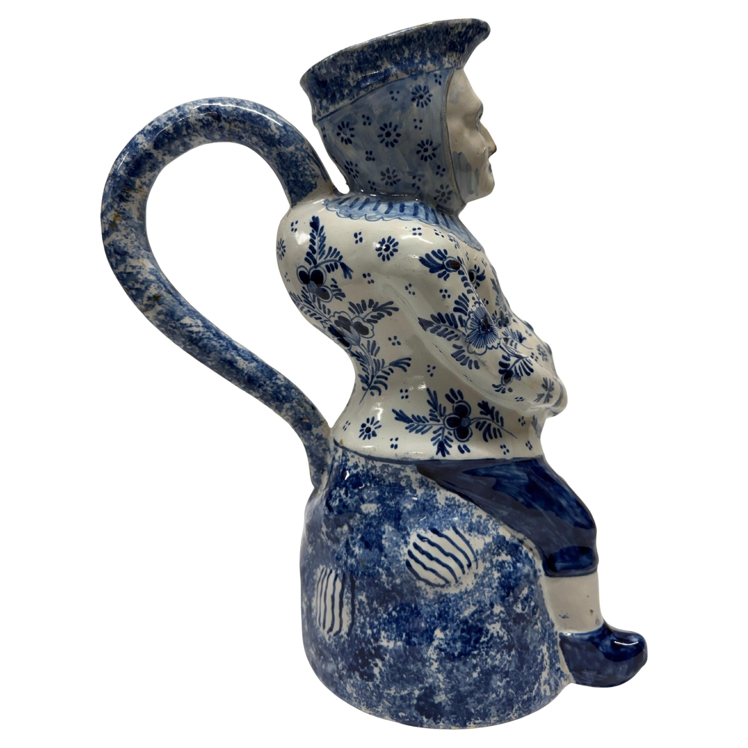 Vase / pichet Toby de Delft du 19e siècle, modelé comme une figure assise peinte en bleu persil, porte une marque de fabricant peinte sur la base. 