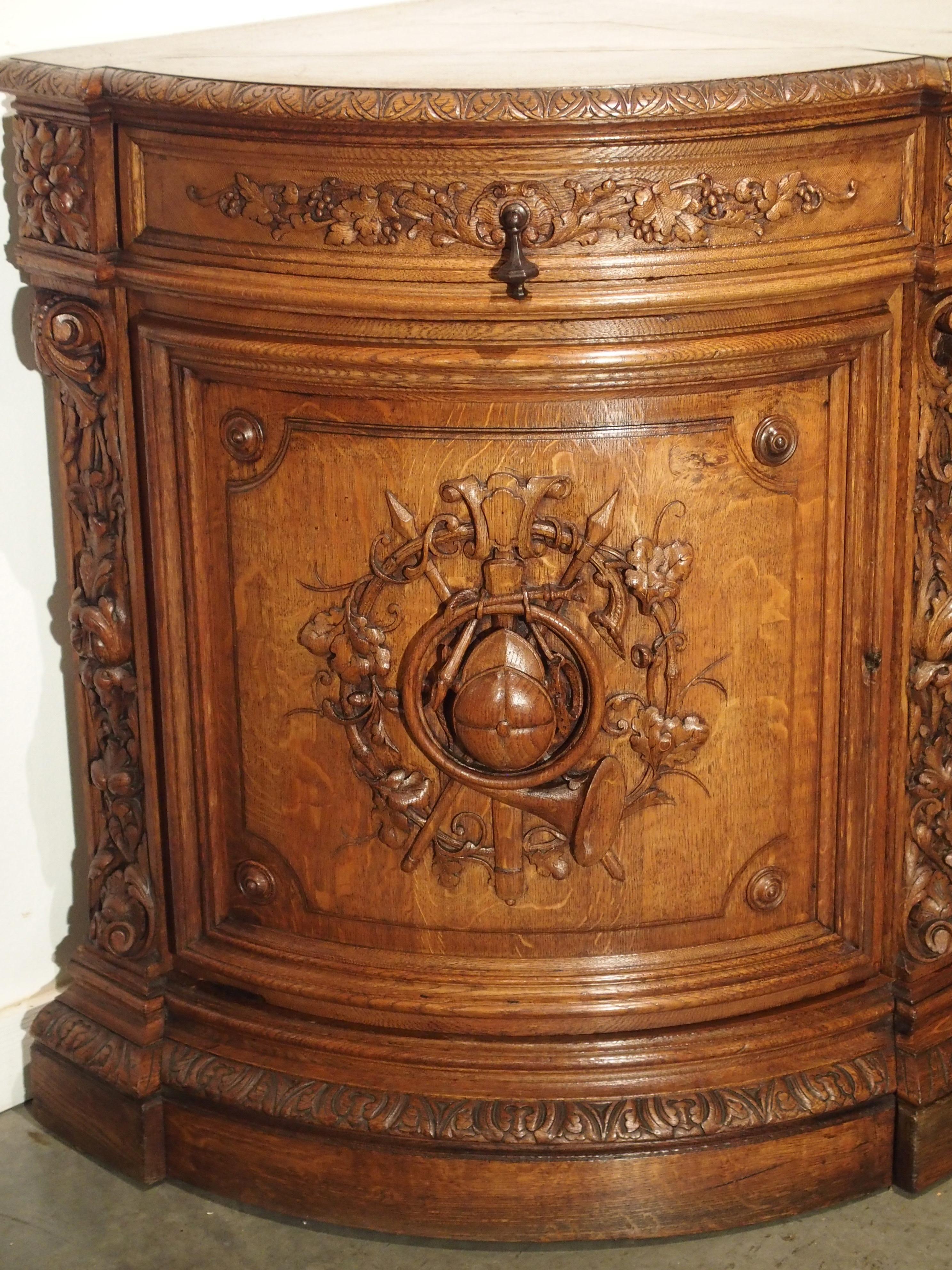 From France, this exceptional, hand carved hunt buffet with curved ends, depicts extraordinarily large versions of beautiful animals. They are featured on the two front cabinet doors. Both doors depict a fox or wolf in shrubbery seeking their prey;