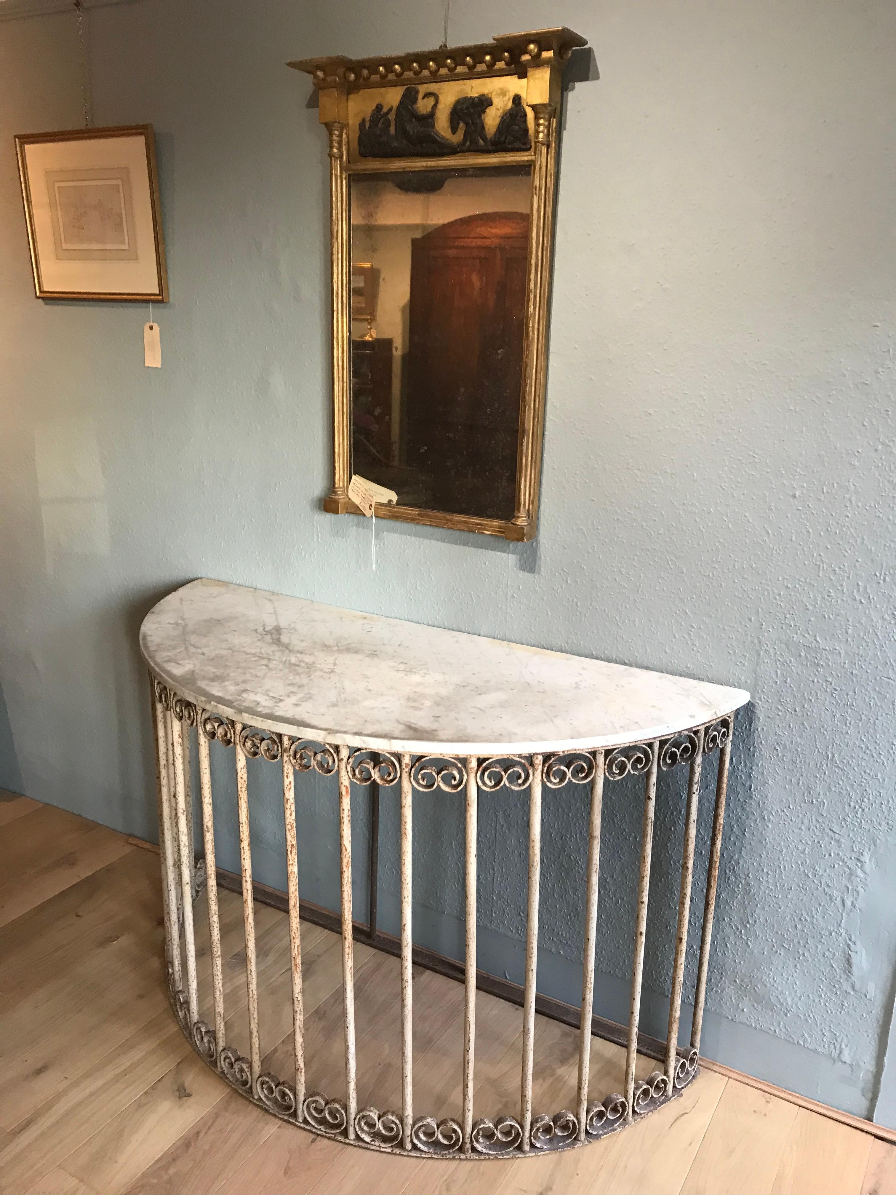 19th Century demi-lune wrought iron and marble topped console table of good scale. This attractive console has a white aged marble top resting on a slightly distressed painted base. The wrought iron base features ornate scroll decorations between