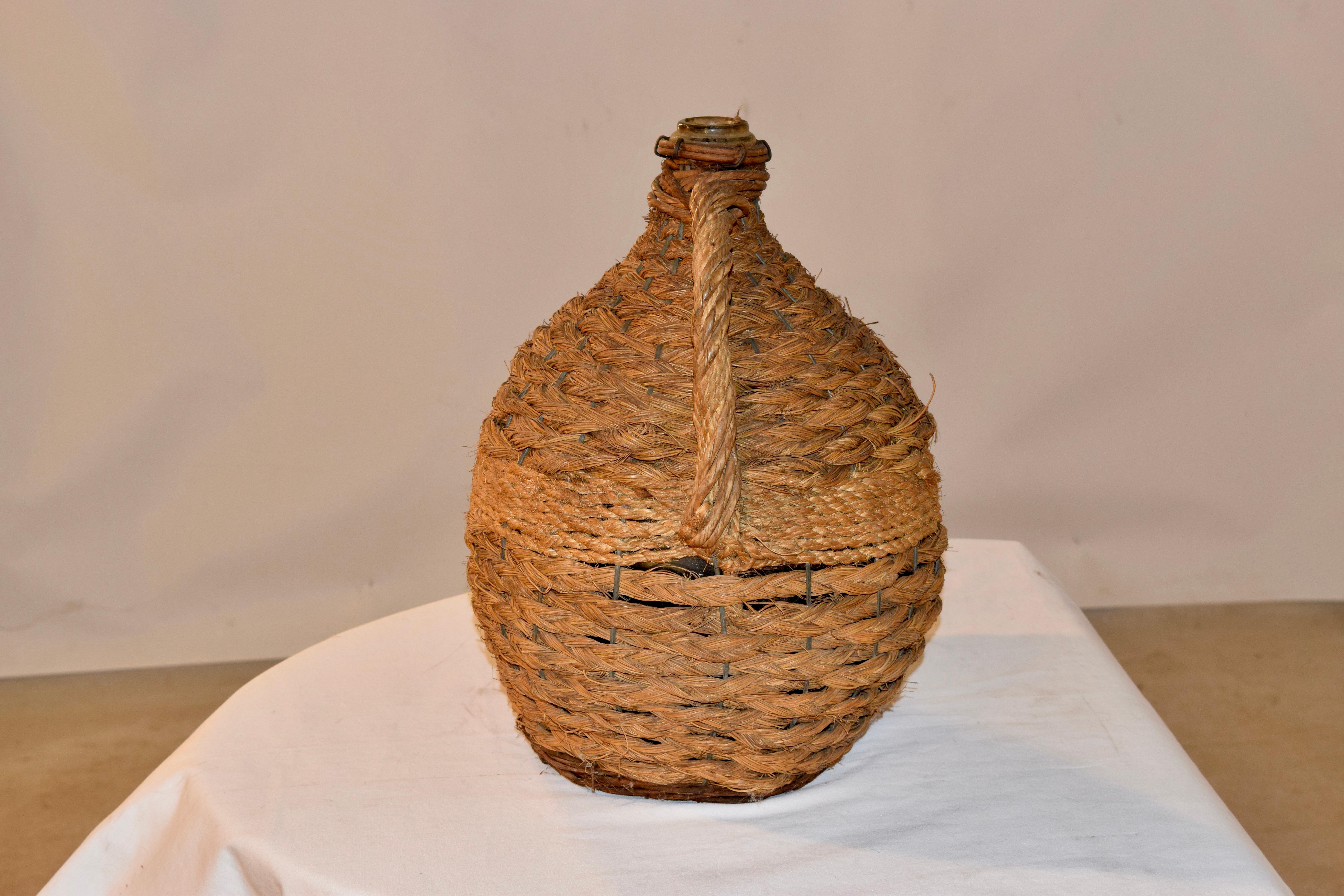 19th century French globular form hand blown glass demijohn bottle encased in original braided rope. Layers of different kinds of rope have been used, which has created an interesting texture.