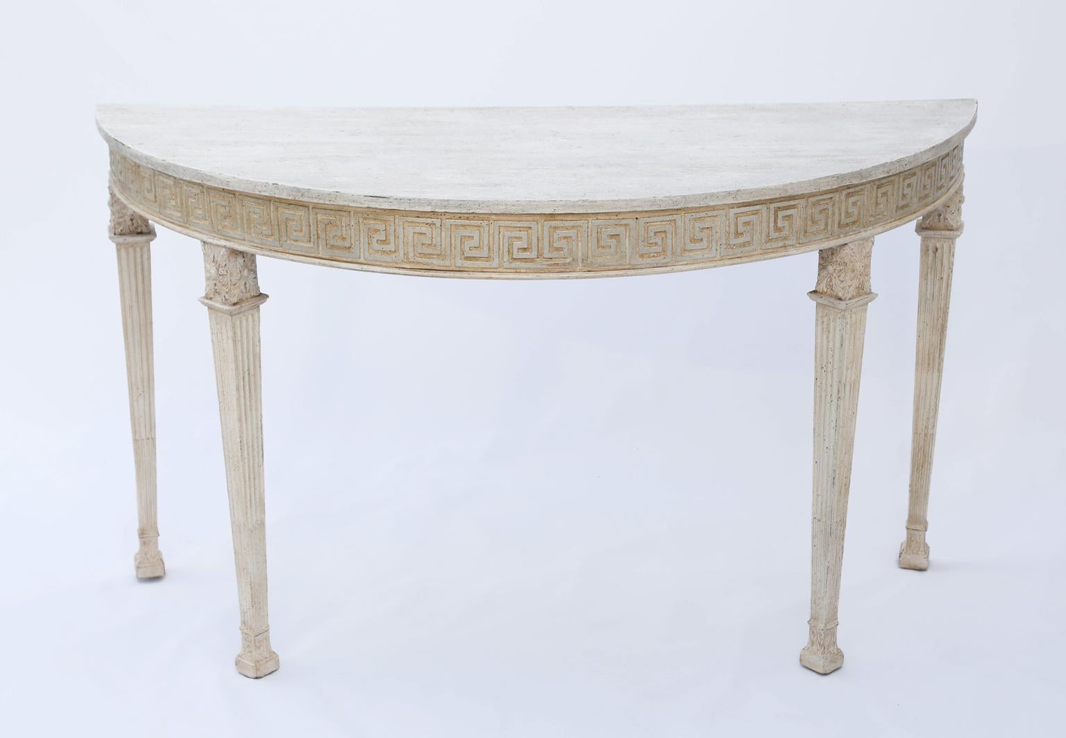 Demilune console table, having painted finis, its D-shaped, faux top, over in-carved Greek-key apron, raised on fluted, tapering, square-section legs, with acanthine knees.

Stock ID: D1020.