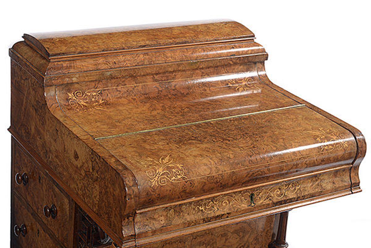 A Victorian walnut Davenport with satinwood inlays.

The hinged piano fold over top enclosing a rising writing - reading surface with a green leather insert and a pair of small drawers; the small knob between them  unlocks the stationary compartment