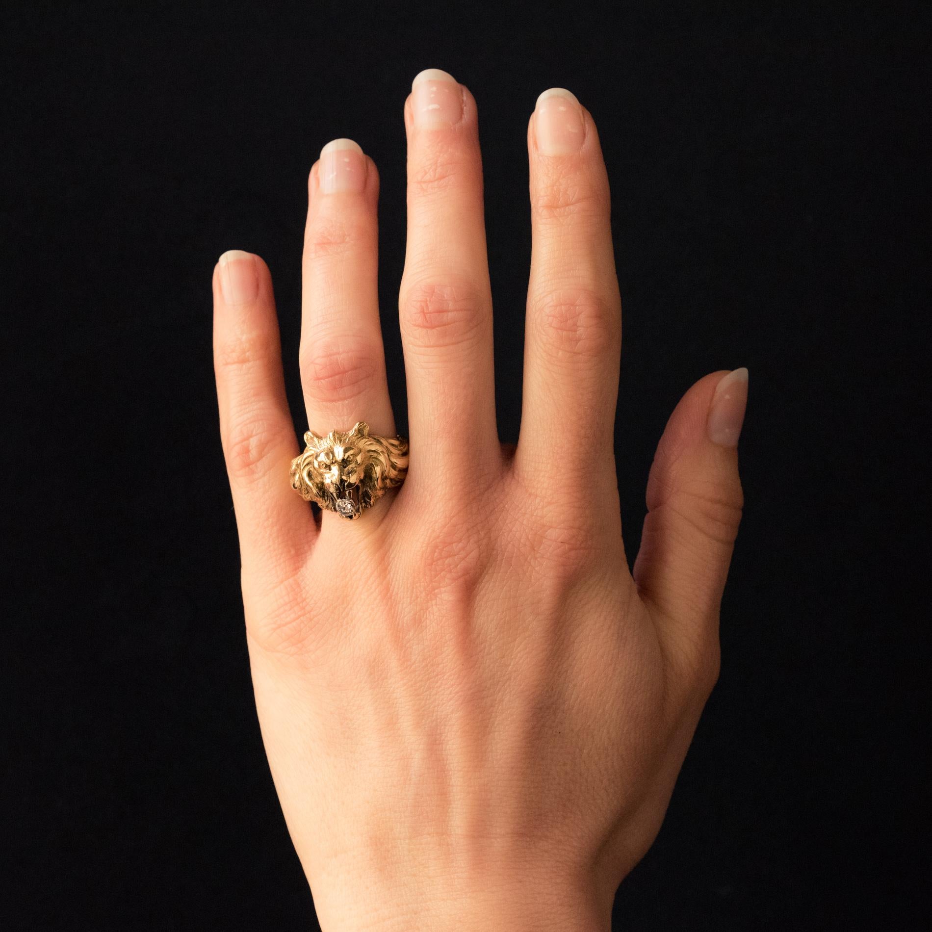 Ring in 18 karat yellow gold.
This sumptuous antique men's ring, represents a lion with its mouth open holding between its fangs an antique-cut diamond in closed setting. The entire mounting is chiseled like the animal's coat.
Total diamond weight: