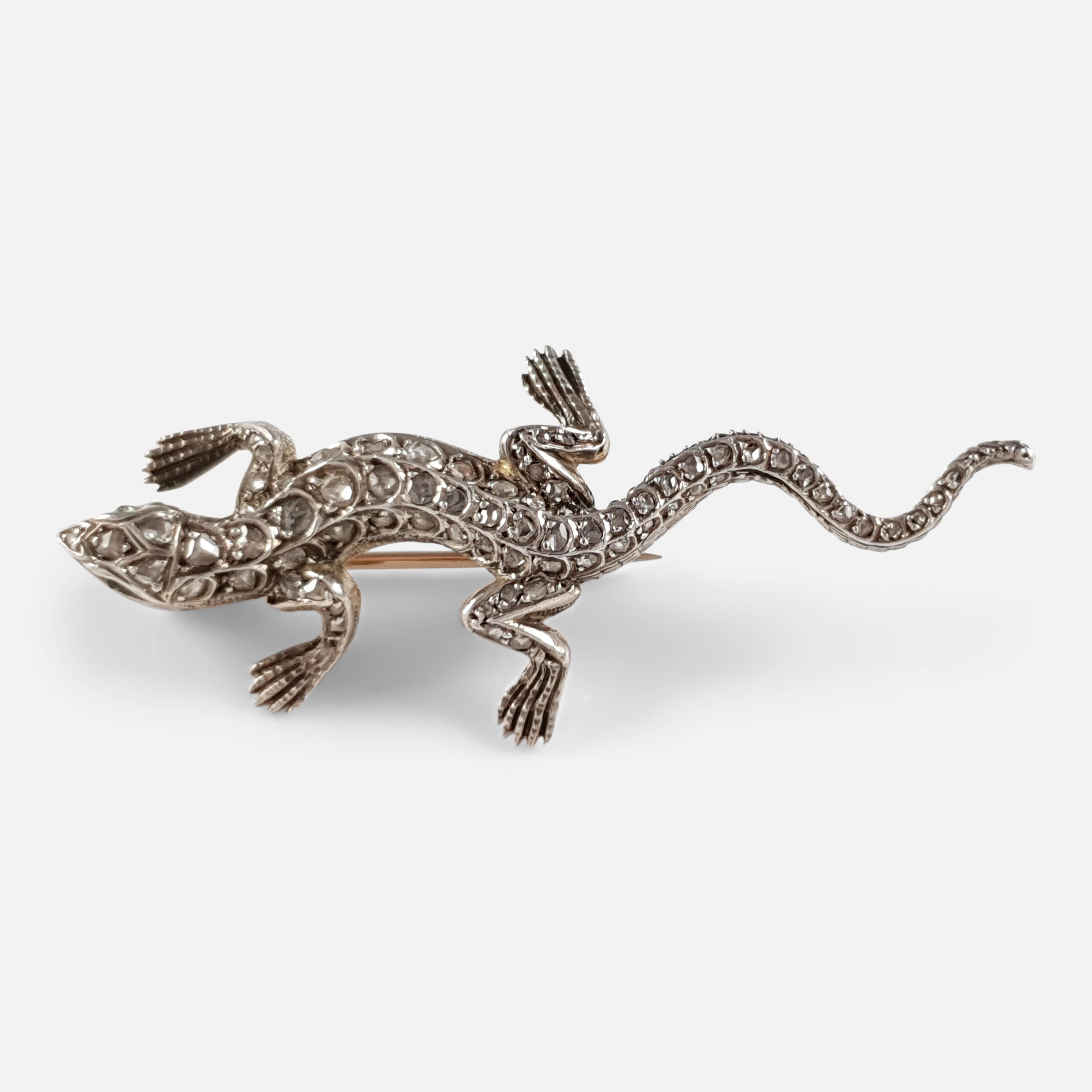 An emerald and diamond lizard brooch, circa 1895. The brooch is crafted in silver to the front and backed in rose gold; with rose cut emerald eyes, an engraved head, body, and tail that is highlighted with graduated rose-cut diamonds. The brooch is