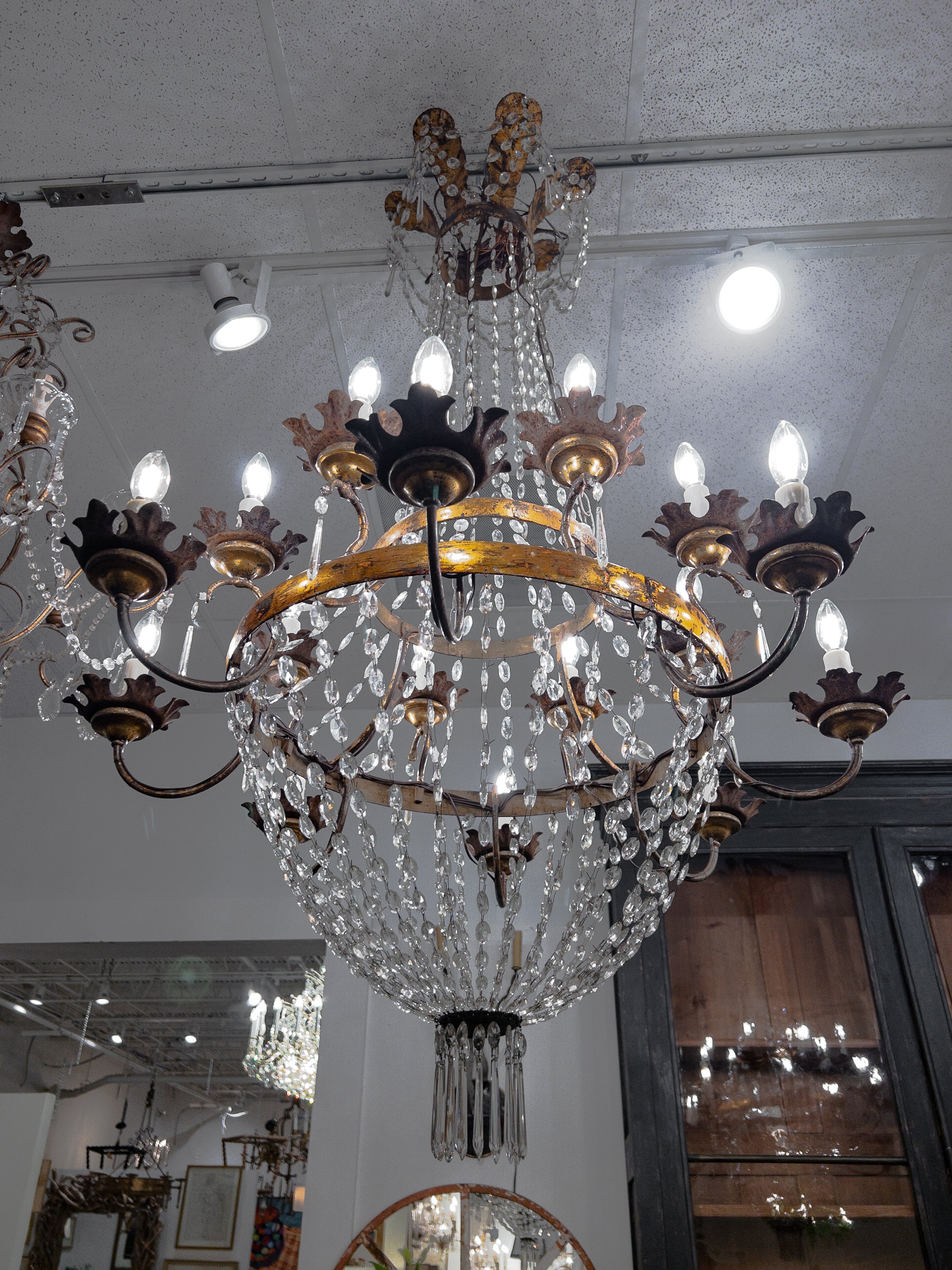 Il lampadario di cristallo in stile Directoire del XIX secolo è un capolavoro di eleganza e opulenza, che incarna la sensibilità del design dell'epoca. Sospeso da un baldacchino in bronzo dorato, questo lampadario vanta un cesto di cristallo