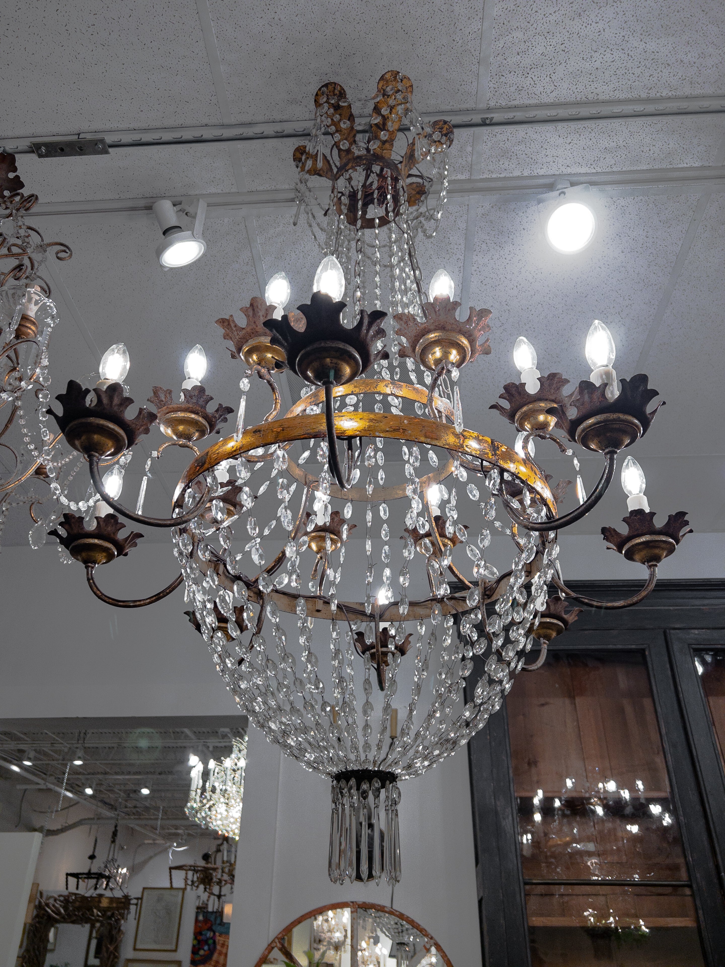 The 19th-century Directoire Style Crystal Chandelier is a masterpiece of elegance and opulence, epitomizing the design sensibilities of the era. Suspended from a gilded bronze canopy, this chandelier boasts an elongated crystal basket as its focal