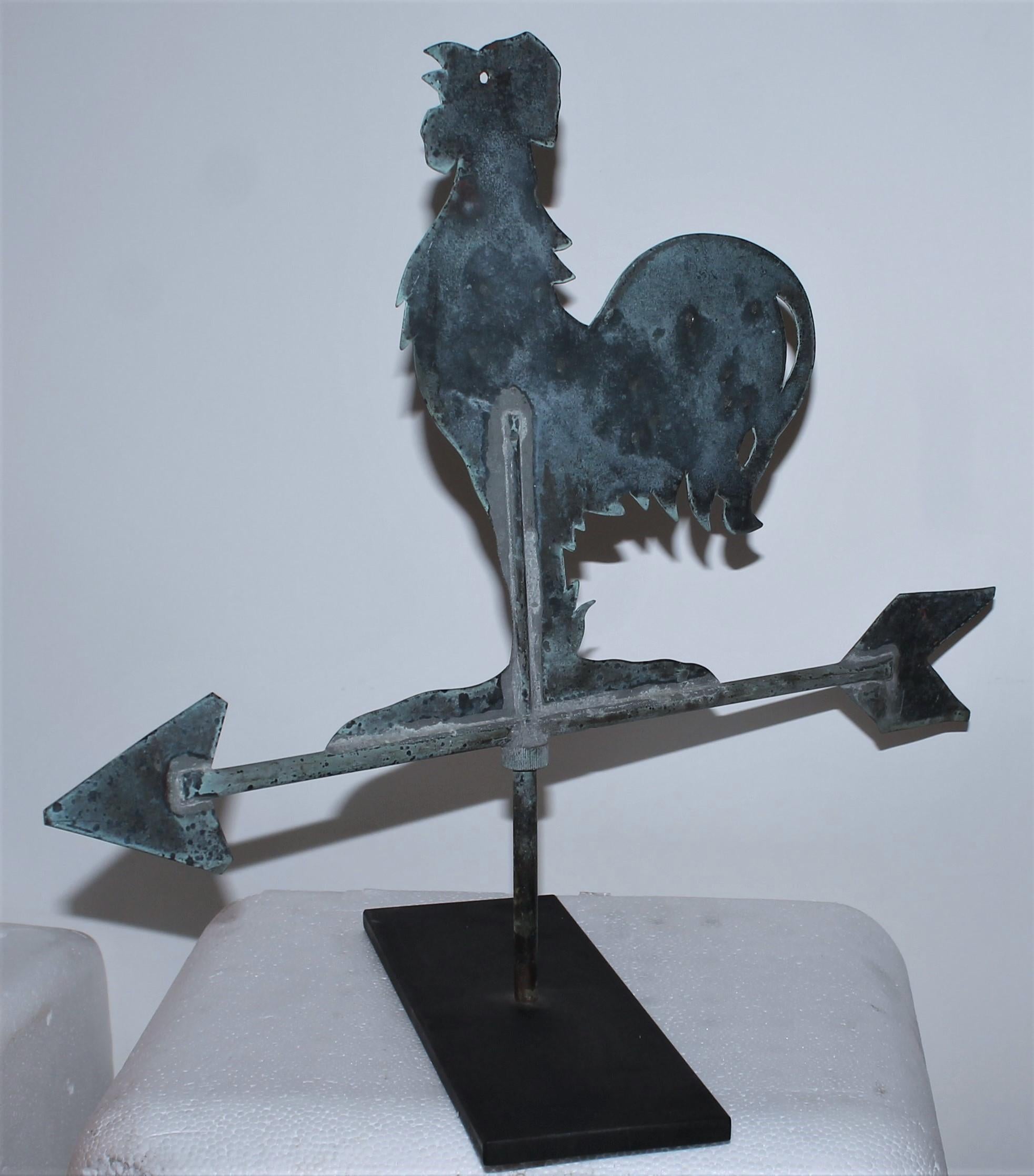 This fine patinaed copper diminutive rooster weather vane is in fine as found condition. It does have old bullet marks and is on its own custom made iron stand. This fine cock has such great patina and could be used on a small barn or house as well.