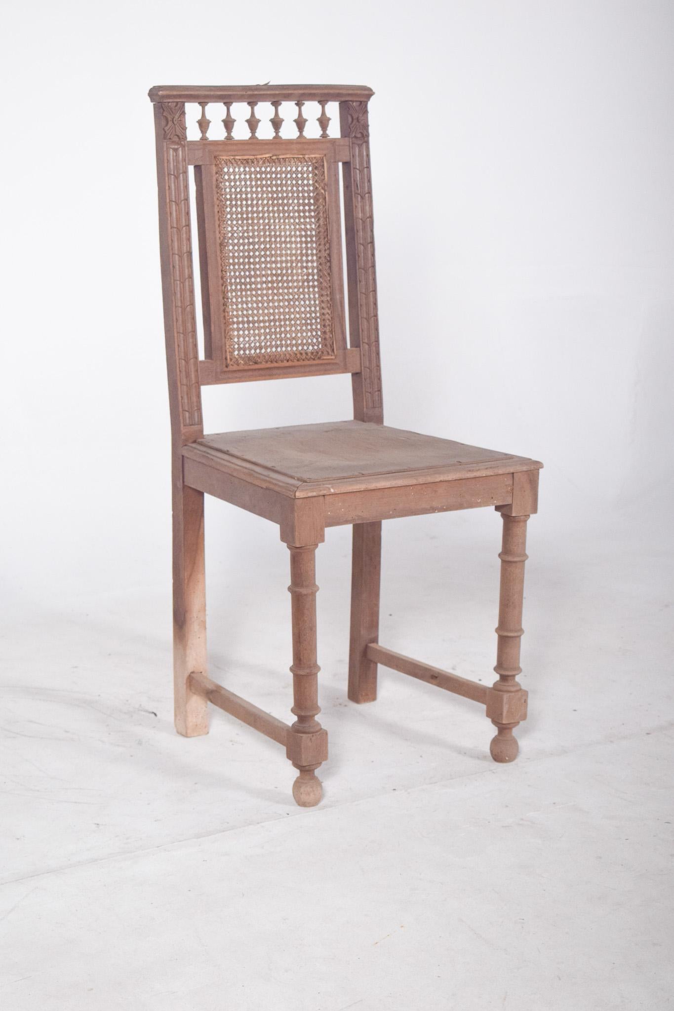Chaise de salle à manger avec dossier en rotin. Avec des éléments décoratifs tournés qui évoquent un style éclectique de la fin du XIXe siècle et du début du XXe siècle, la partie supérieure du dossier est ornée de petites colonnes tournées,