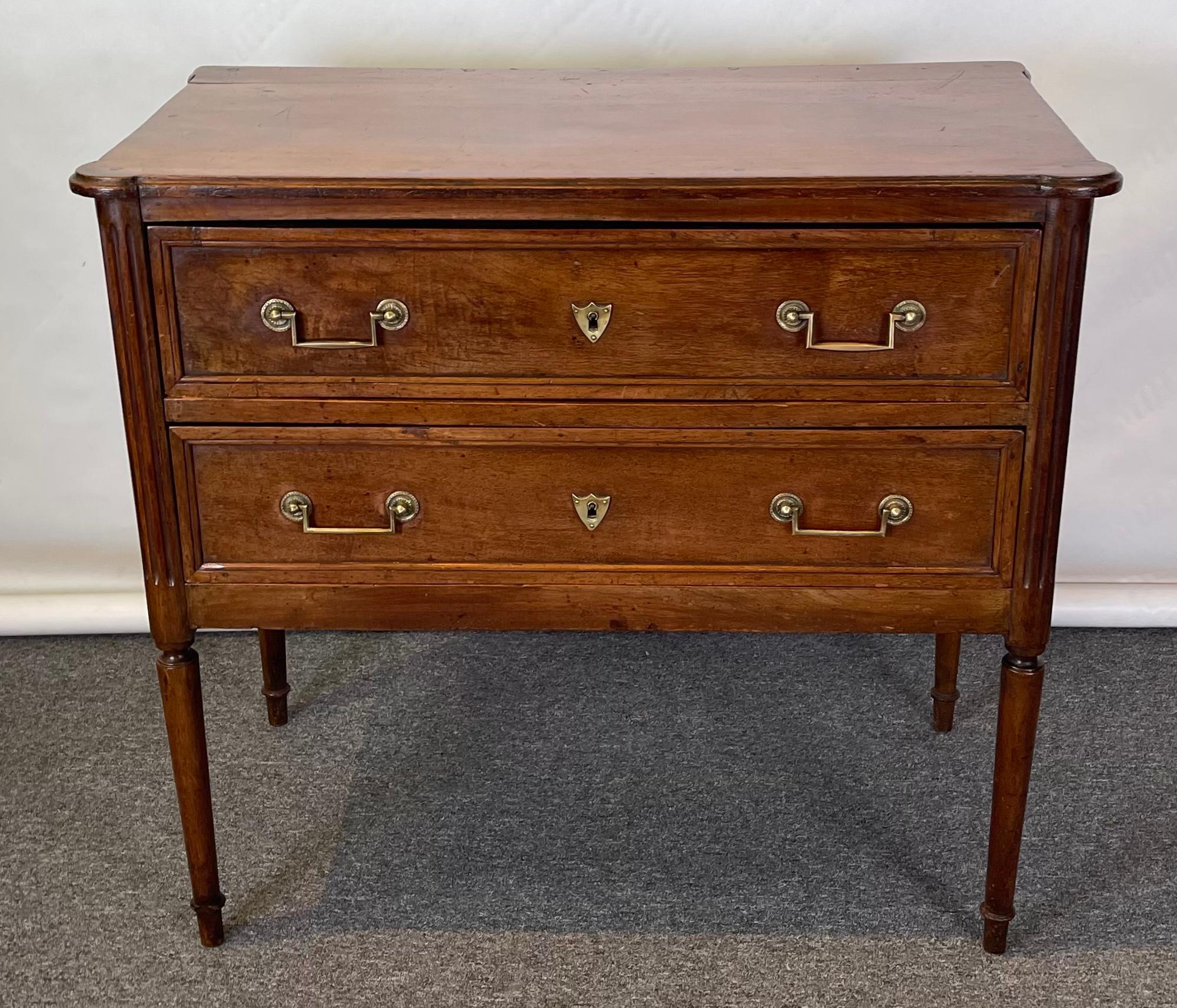 A late 19th C. French Directoire style two drawer cherrywood commode with lovely mellow patina on delicately turned legs.