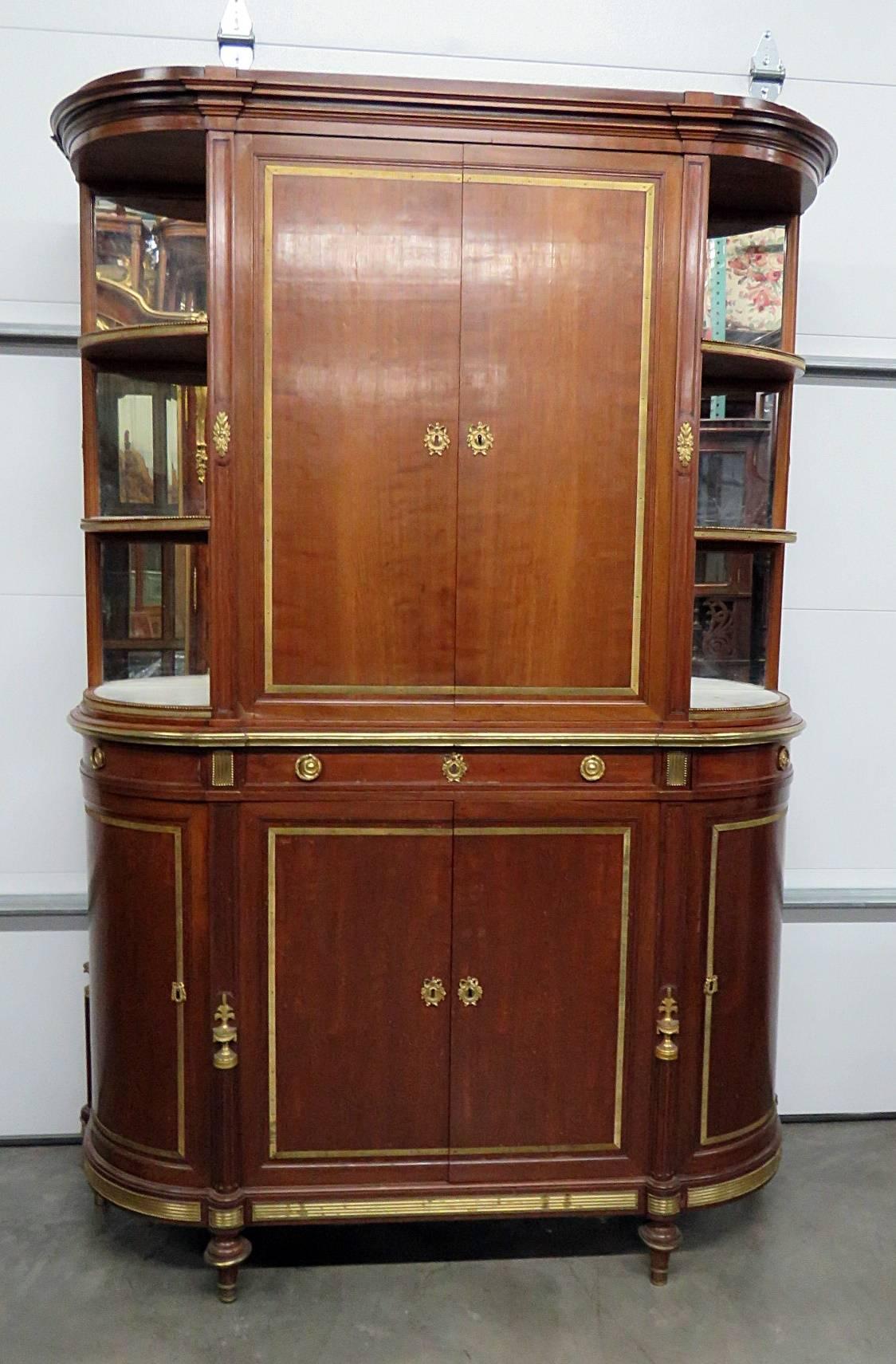 19th century signed Francois Linke Directoire style China cabinet with bronze mounts. The top has two doors containing two shelves and three open shelves on each side. The bottom has three drawers over four doors. We have recently discovered that