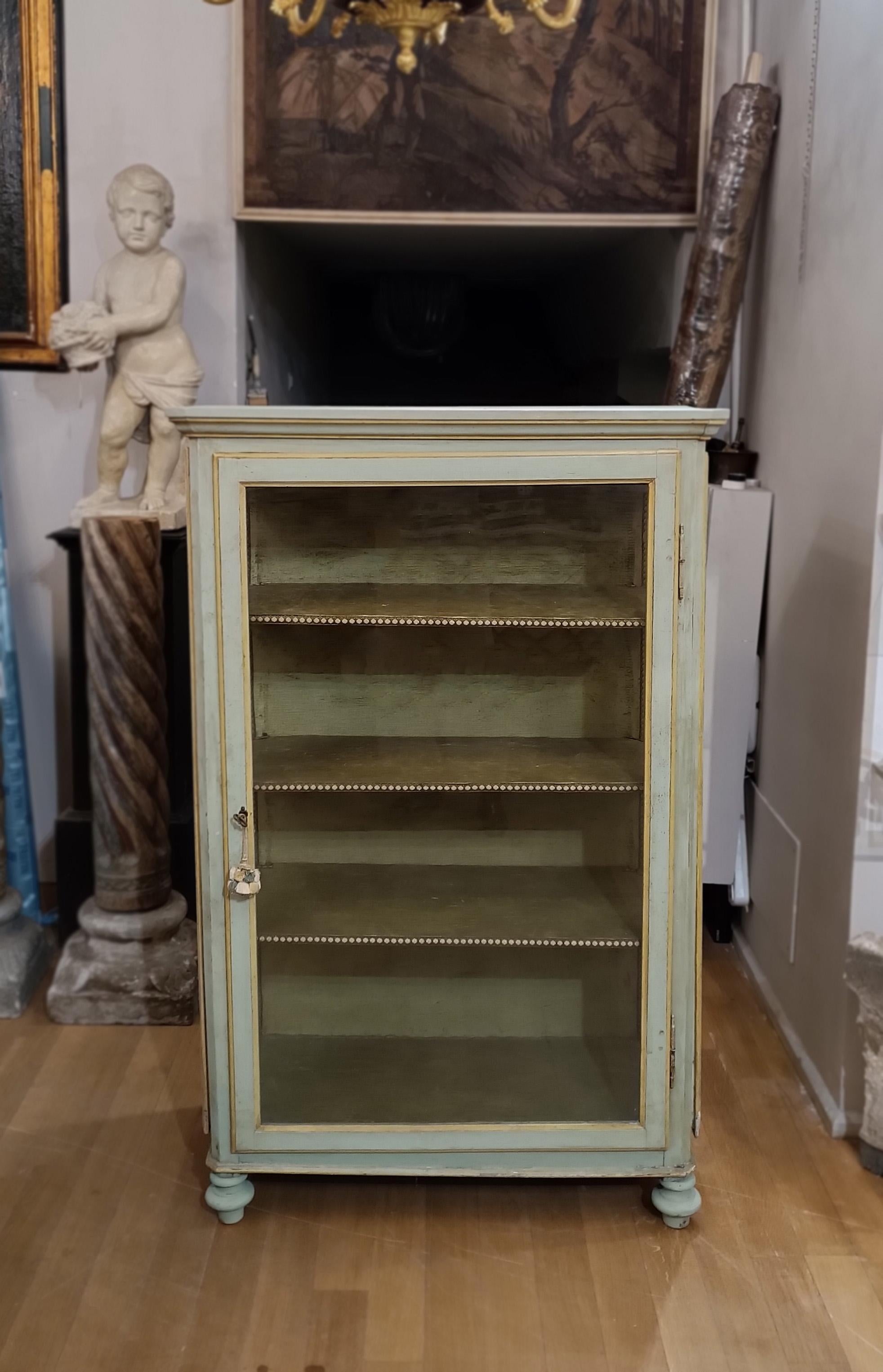 Beautiful display cabinet in poplar wood painted with lean tempera in a striking green and yellow duotone. Its authentic beauty is enhanced by the original glass, which also extends to the sides, allowing a complete view of the objects on display.