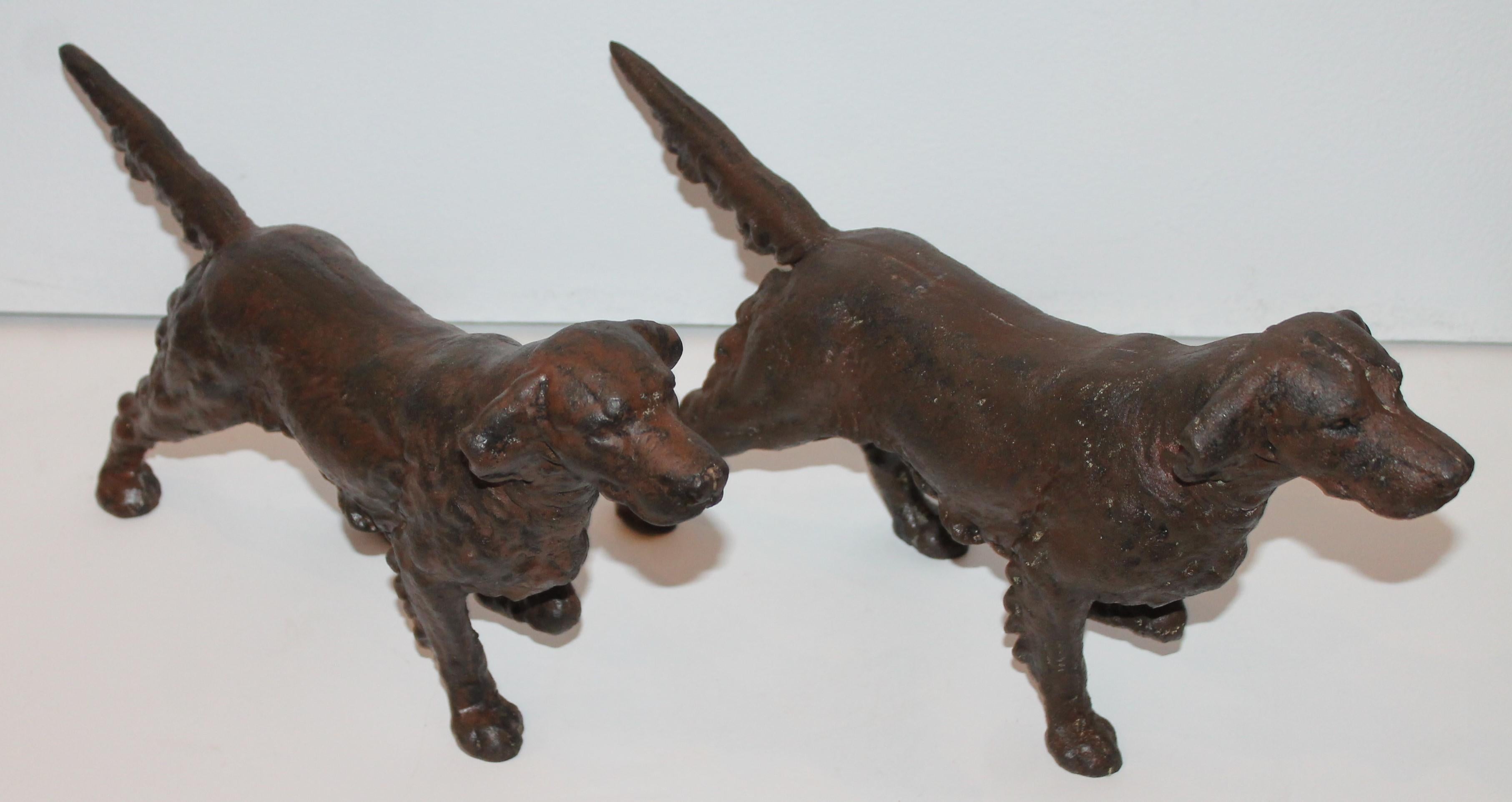 This pair of cast iron dog doorstops in the original worn surface. These dogs were unpainted as many are with old paint or re-painted surfaces. They are in the natural iron patina.