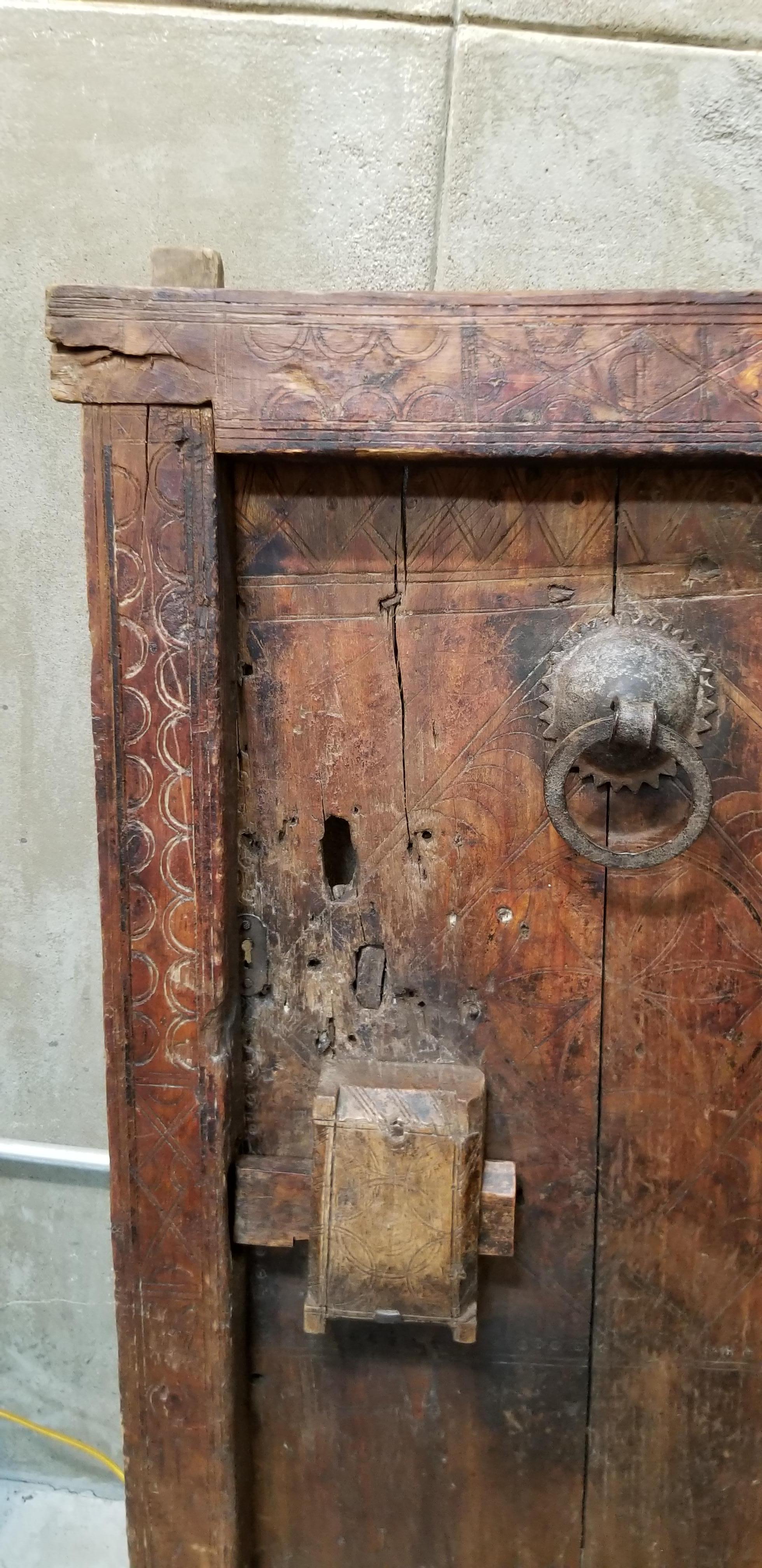 Handcrafted granary door from the Mali tribe, West Africa. Shows its decades of use with beautiful wear and patina with lots of character. Retains original door casing and/or frame. Slide lock mechanism intact. Geometric hand-scribed carved detail.