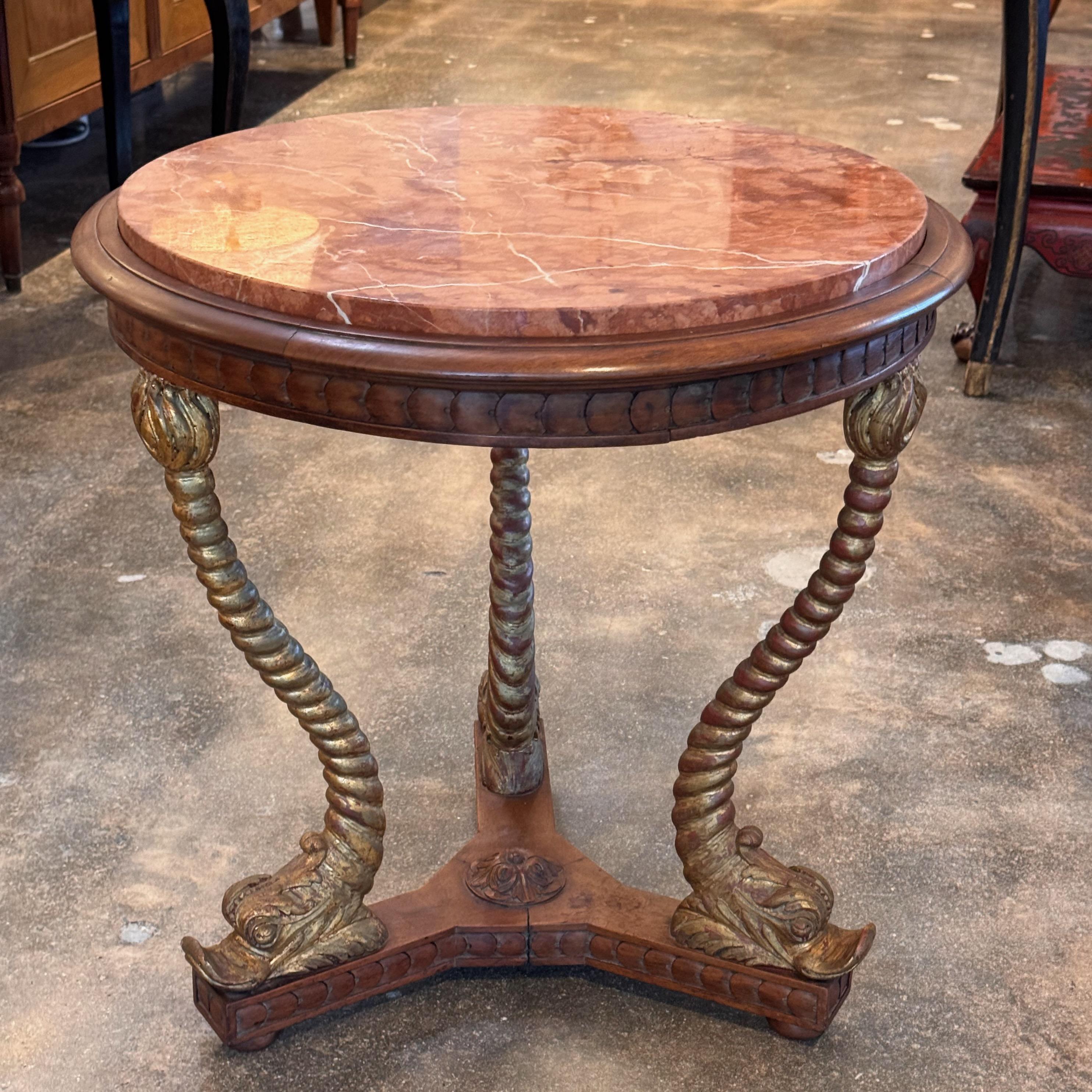 This table has so much style. It has a gilded dolphin base and a marble top.
