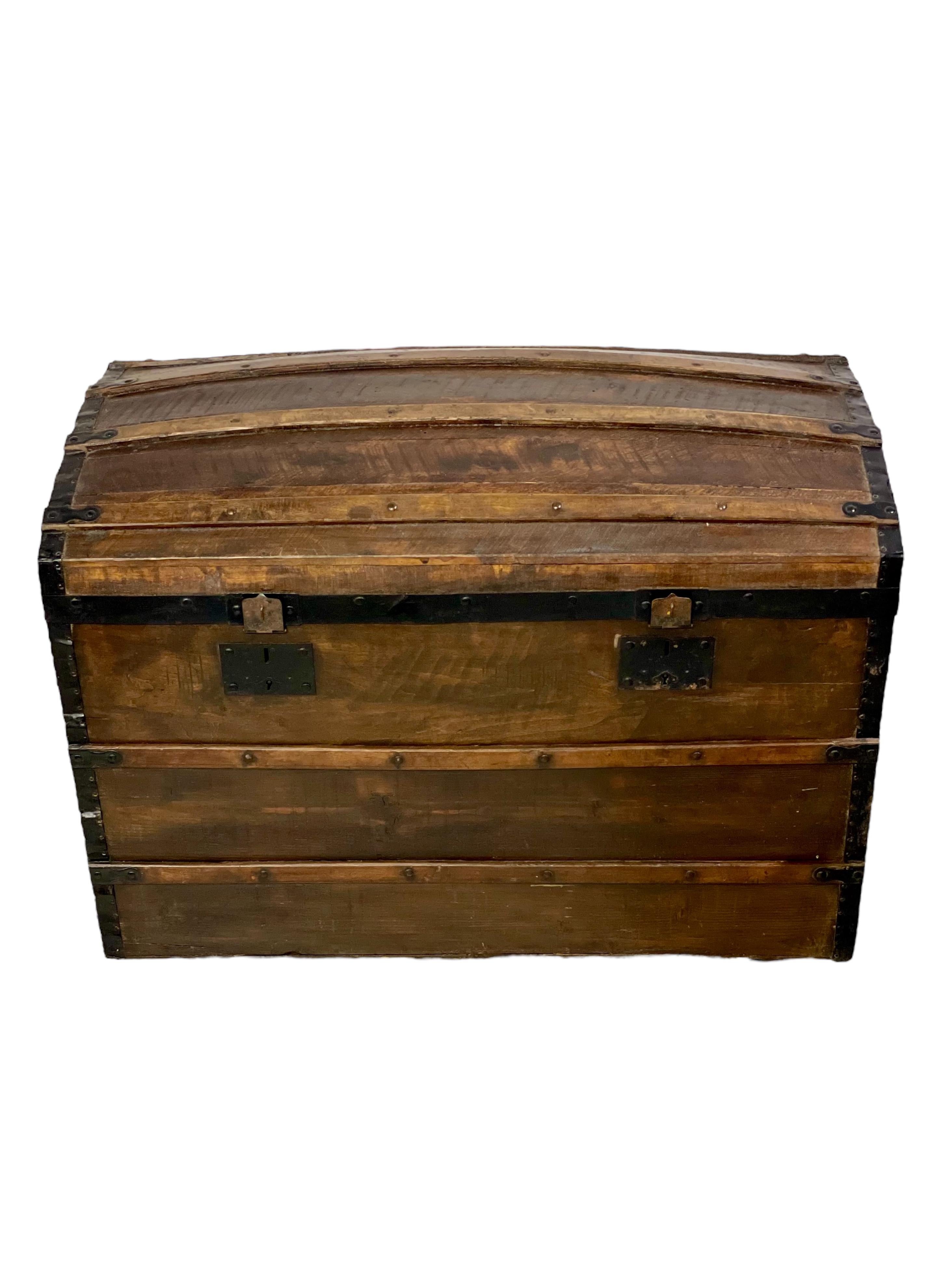Ajoutez un élément d'histoire à votre maison avec cette superbe malle ancienne en bois, datant d'environ 1880-1890. Fabriquée à la main en pin massif, cette charmante pièce a été conçue à l'origine pour les voyages, avec un couvercle en forme de
