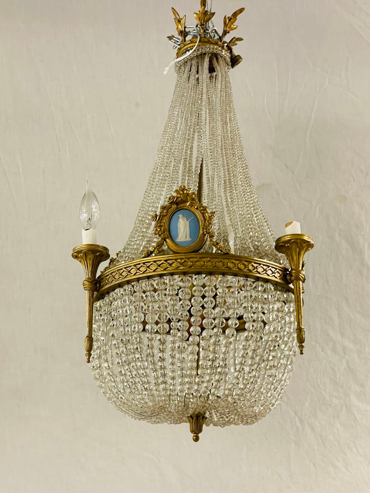 Ein Kronleuchter aus vergoldeter Bronze aus dem 19. Jahrhundert im Louis-XVI-Stil mit bronzeumrahmten Keilholzplaketten, das Ganze mit Kristallfahnen, die in einer Krone aus Dore-Bronze enden.