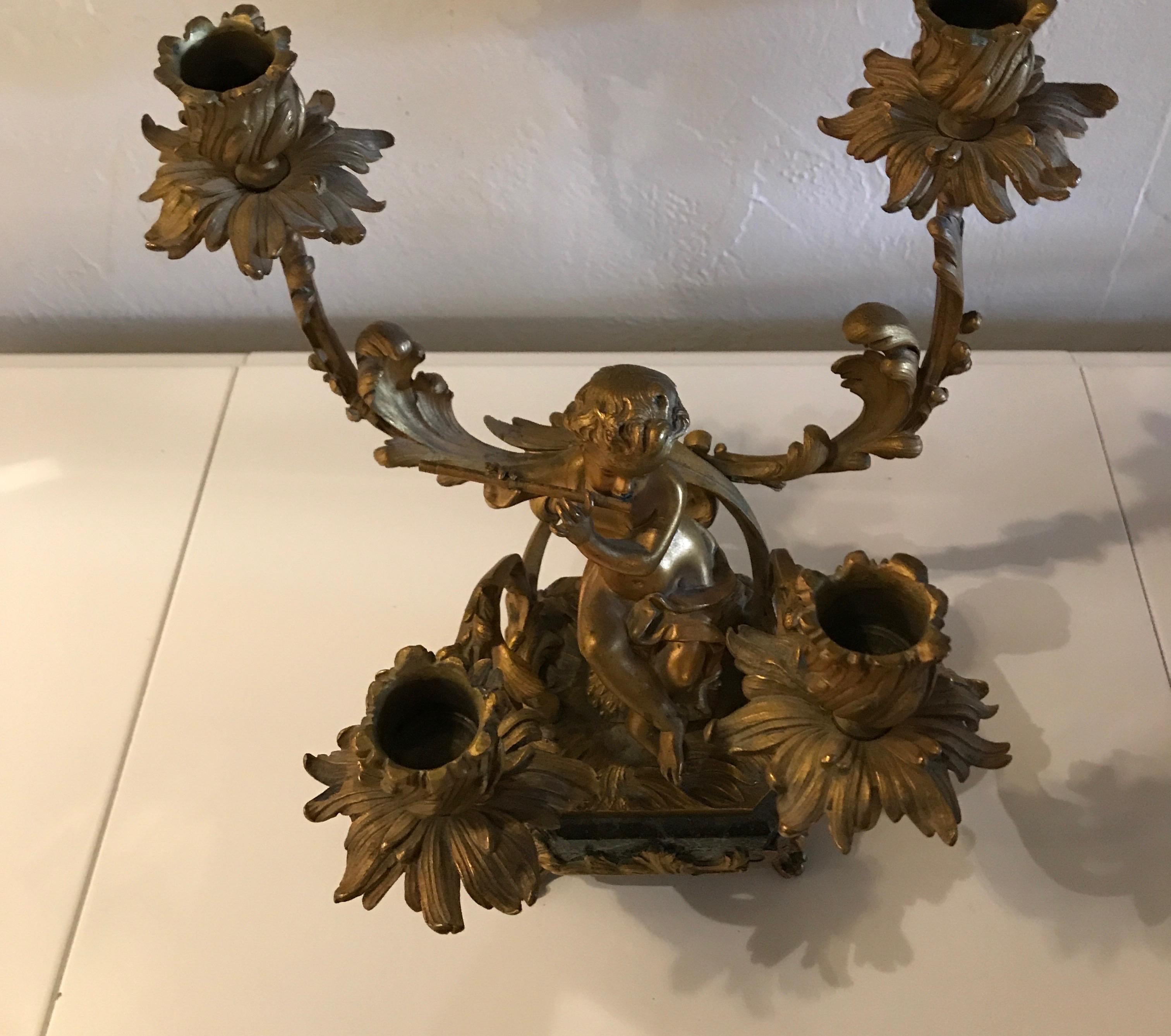 Antique doré bronze candelabra of cherub on marble base. Holds four candles.