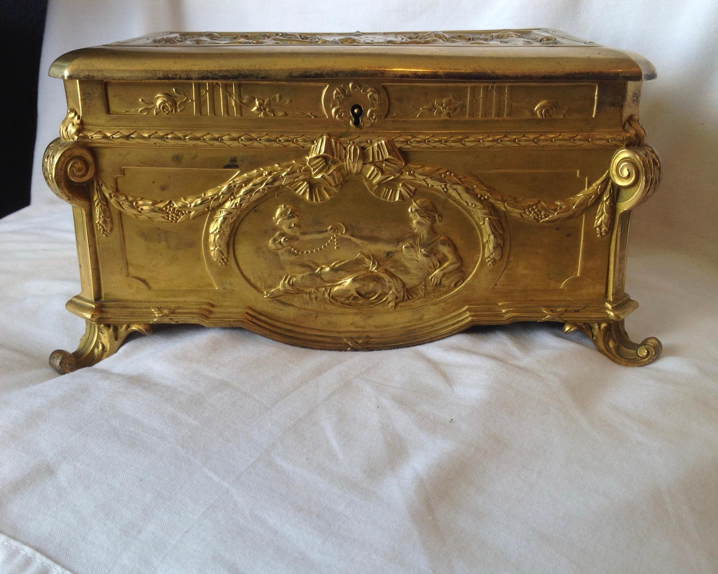 A fine example with classical medallions front and back -
complemented by an elaborate top fashioned with cherubs.
Opulent design. The box is velvet lined.