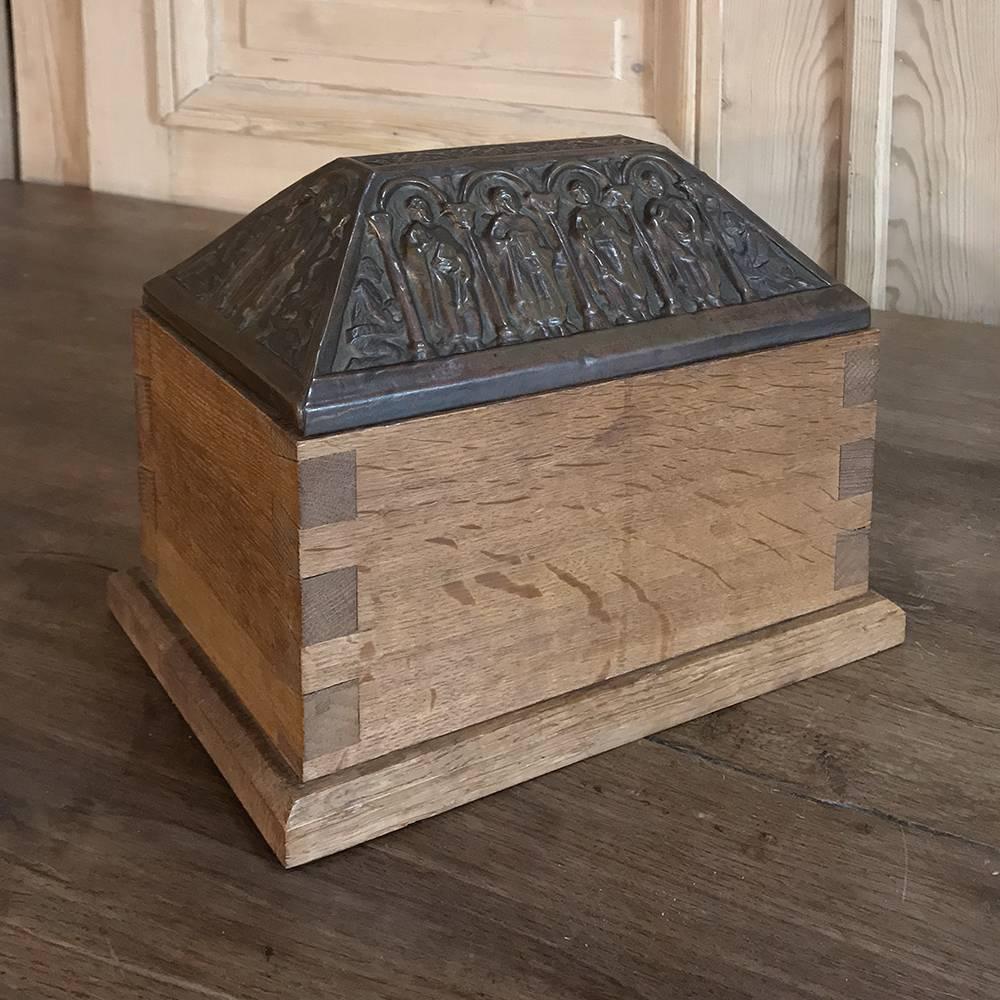 19th century dovetailed wood box with pyramidal patina cast brass lid features raised figural relief appearing to be ten of the apostles. The lid rests upon a meticulously handcrafted oak casework with dovetailed joinery. Ideal for the desktop or