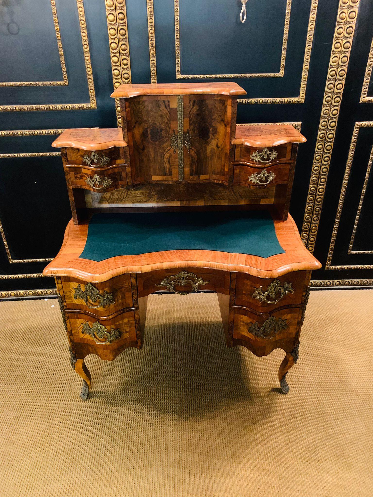Excellent Dresden Baroque desk, On three sides and in the top plate walnut root on solid softwood. The curving, straight, and one-piece body, framing the open knee-box, is curved in the front. In each of the halves there are two pushers over the