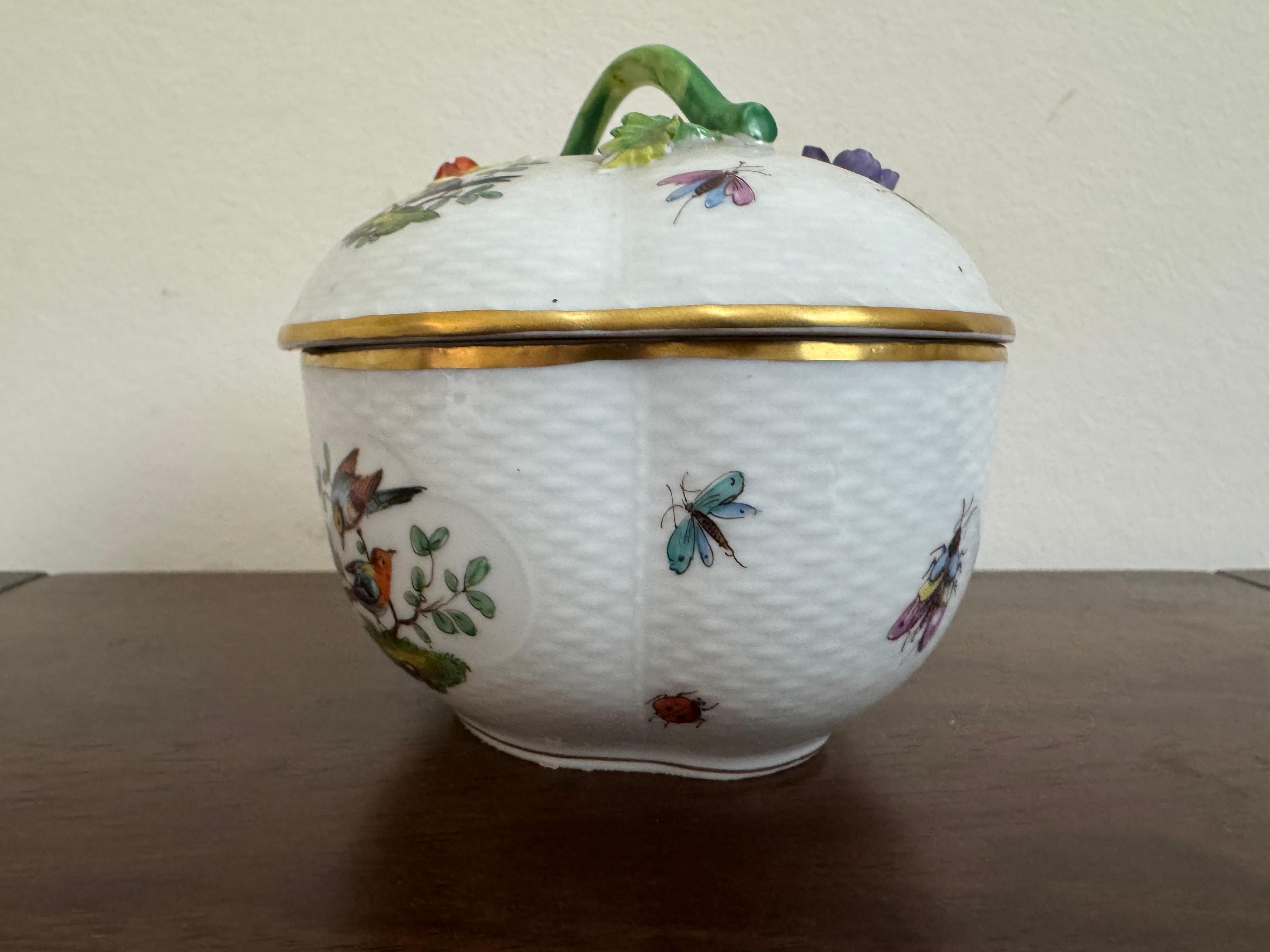 Cuenco con tapa para popurrí de porcelana de Dresde del siglo XIX, de forma redondeada y lobulada con tapa abovedada, y borde y asa festoneados con elementos florales aplicados (hojas y una baya). Tiene un asa verde con un remate de bayas rojas y