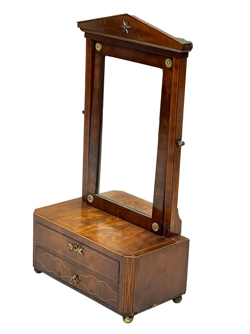 19th Century Dressing table mirror in Empire style

A dressing table mirror with tiltable mirror, which is fixed to the side with 19th century screws. 
The table mirror has 2 drawers. The top drawer has copper fittings in the shape of swans. The