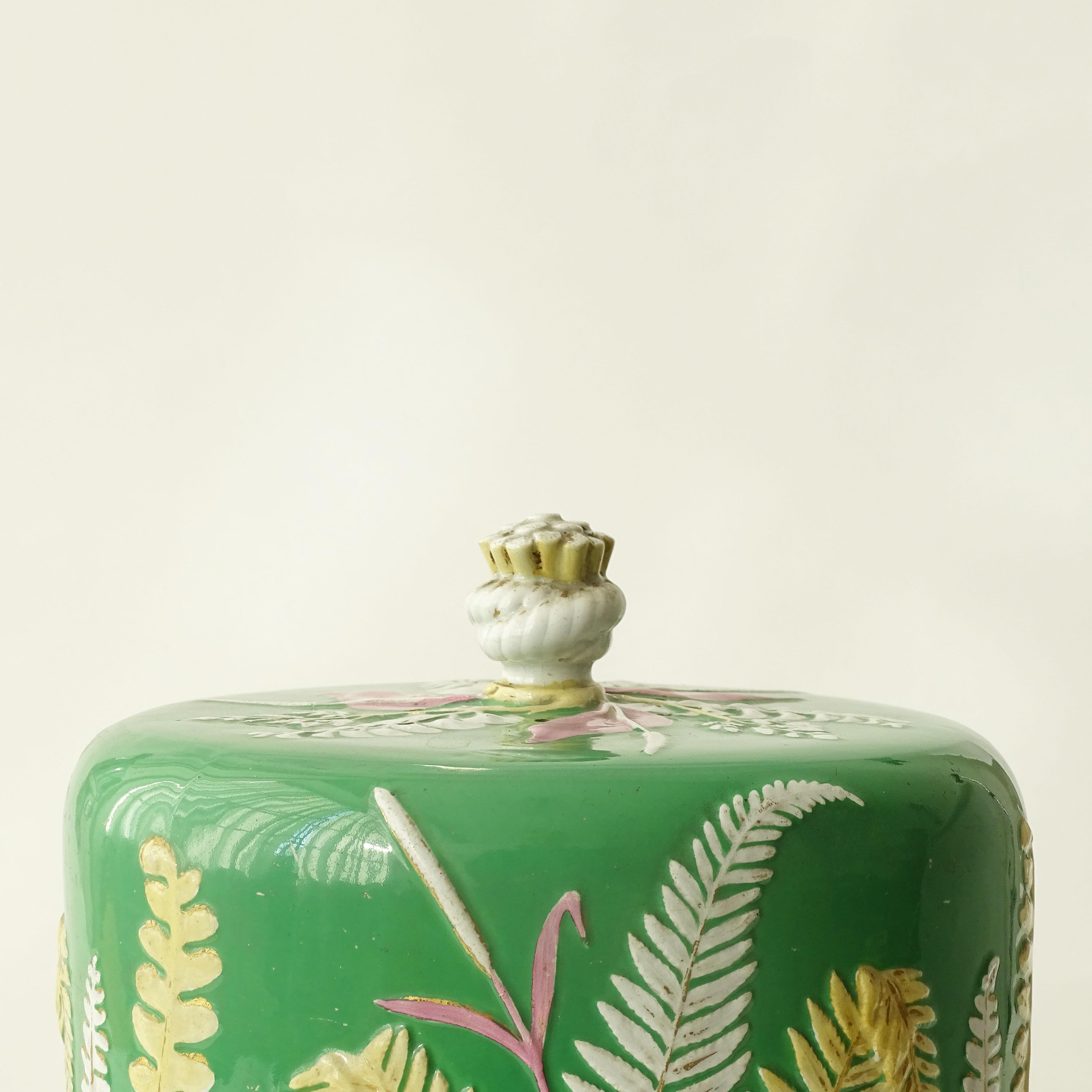Dudson stoneware cheese dome and dish.
The dome is in a magnificent green decorated with low relief applied fern leaves and grasses in white, yellow, and pink.

