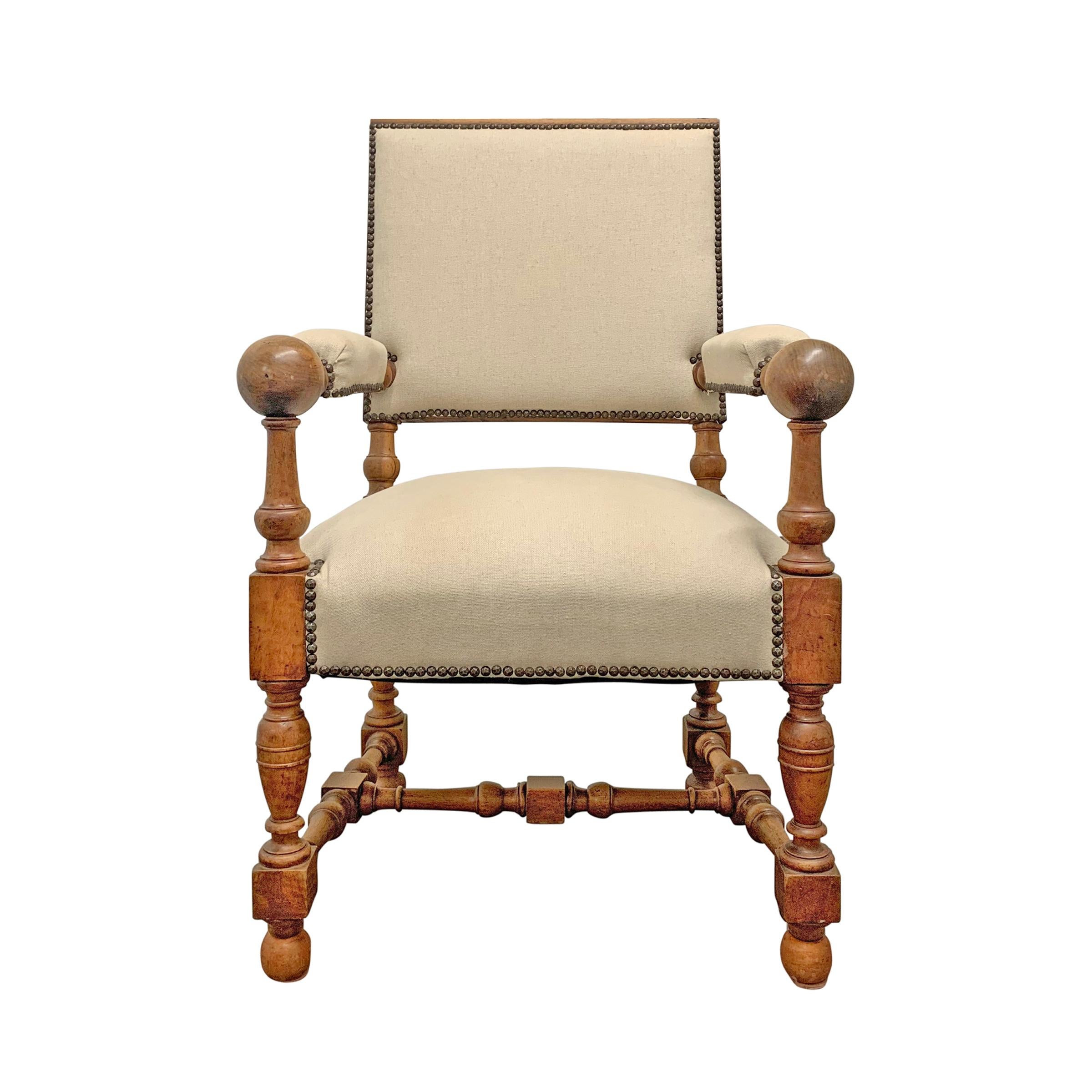 A robust and playful 19th century Dutch turned tiger maple armchairwith wildly sculptural form, a slightly pitched back, and newly upholstered in a beige linen with nailhead trim.