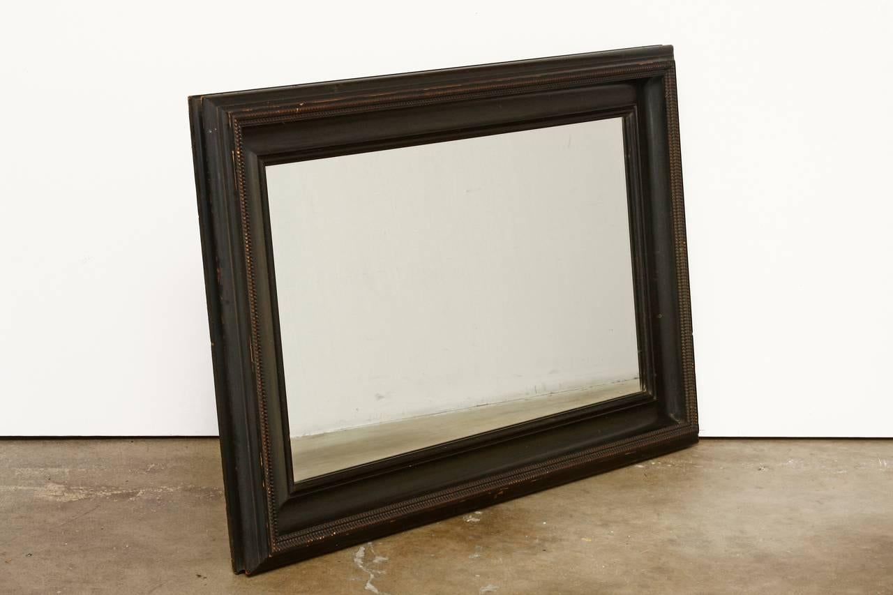 Rare 19th century ebonized mirror made in the Dutch Baroque style. Features a deep frame with a unique bead notched design detail. The frame has a beautifully distressed finish probably made in the Netherlands or Northern Europe.