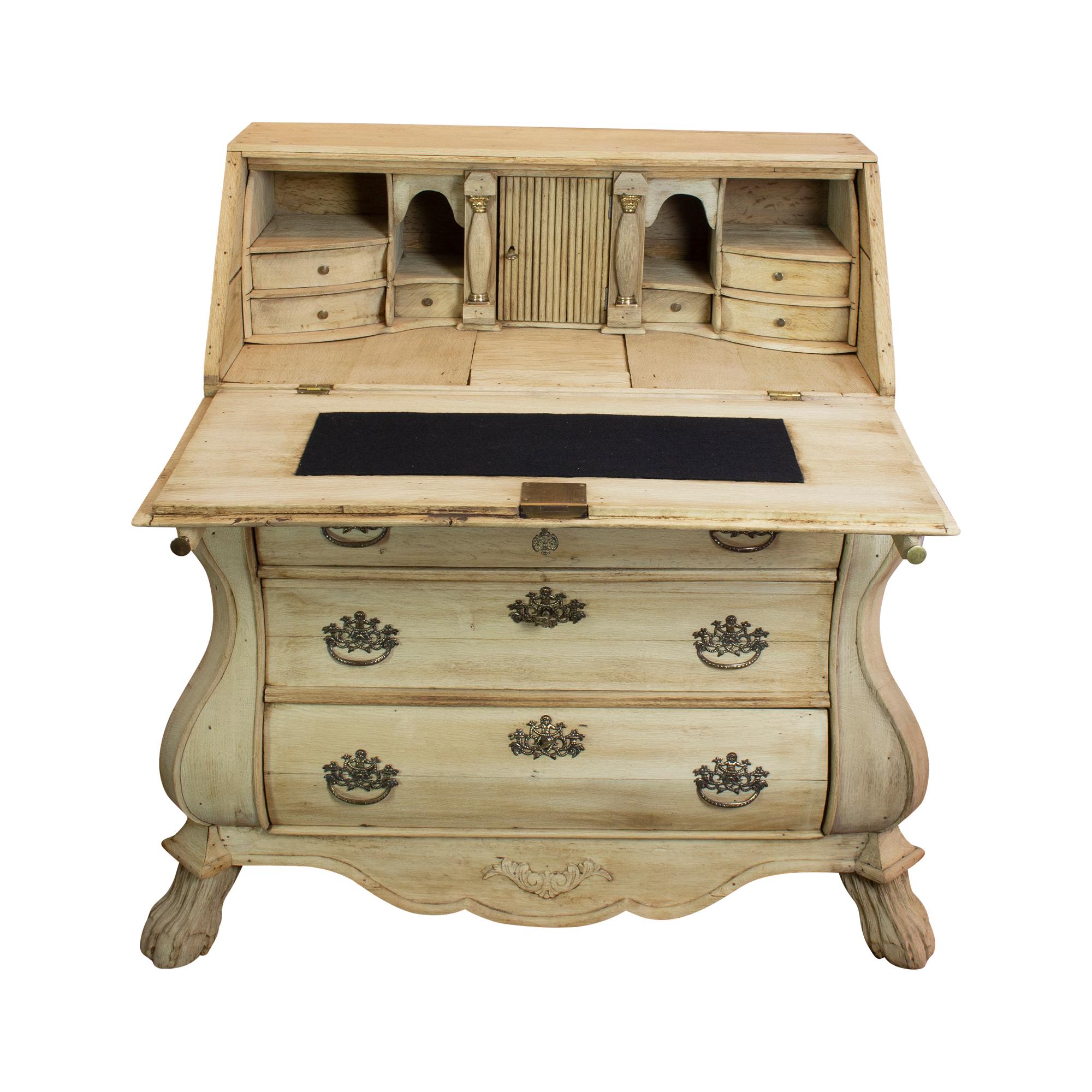 The secretary made of Dutch oak from the 19th century rich in decorations consists of an upper and lower part. The upper part is hinged to the front. The flap sits on two pullouts that must be pulled out first. In the inner part of the secretary