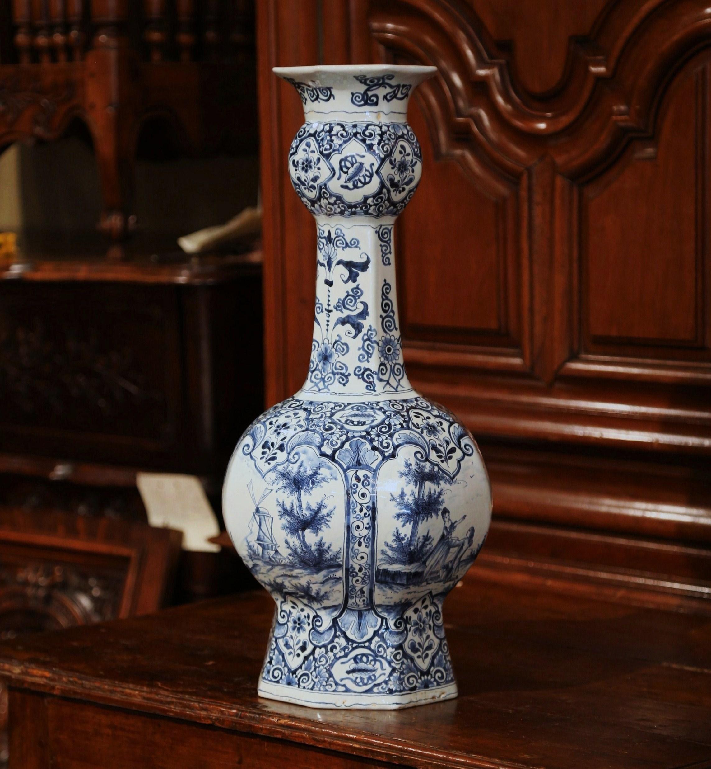 Place this large antique delft vase in your entryway for classic, traditional style. Crafted in Holland, circa 1850, the tall faience vase is beautiful in shape and form with a rounded body and a long, thin neck. Hand painted in the traditional blue
