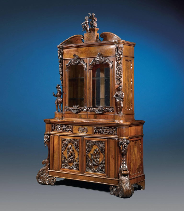This magnificent and important Dutch mahogany bureau bookcase, exuberantly carved and adorned with superb figural carvings, impressive scrolled feet and elaborate applied decoration. Such lavish works as this were considered status symbols on the