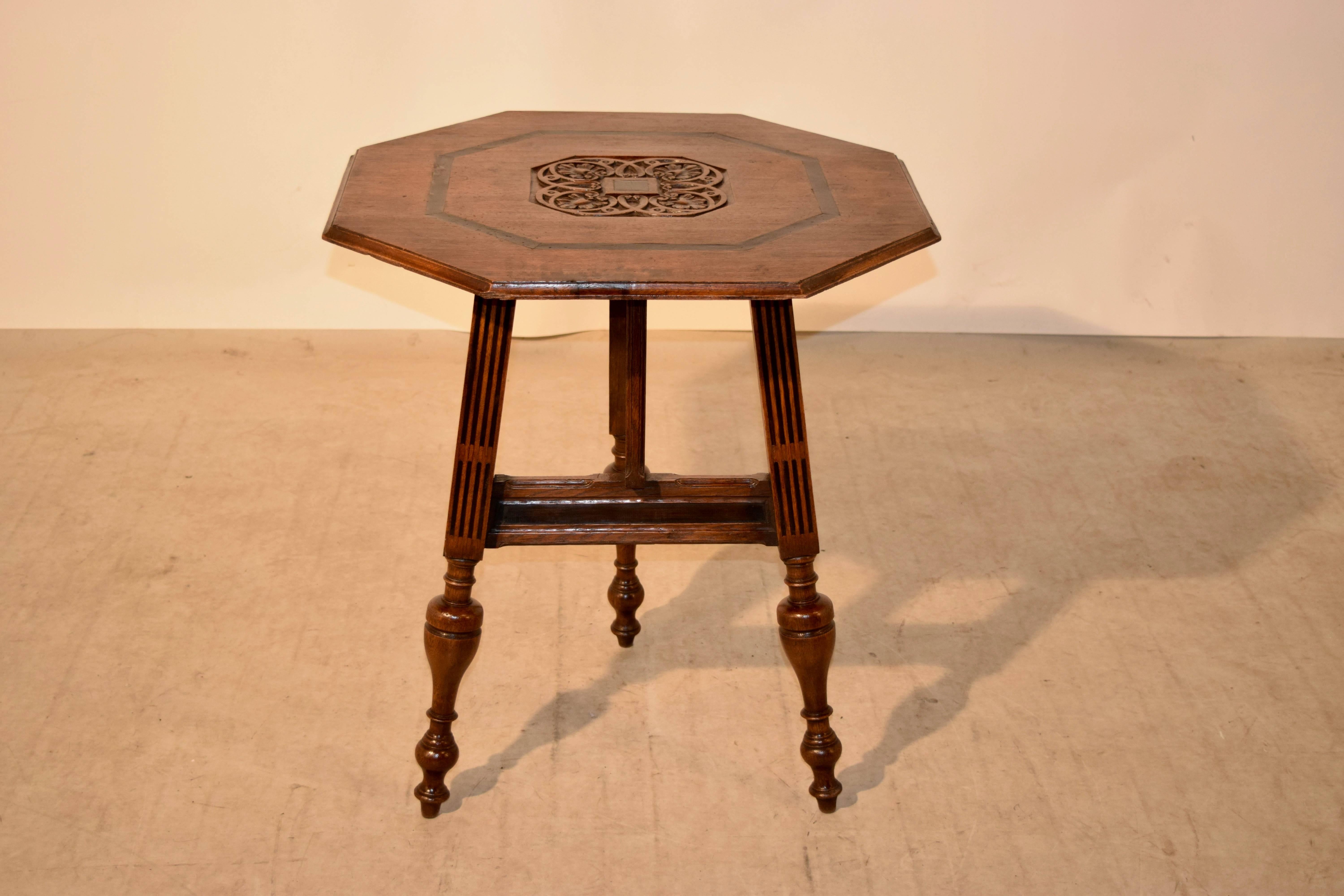 19th century Dutch oak carriage table which has a central carved medallion on the top, surrounded by ebonized banding and a bevelled edge. The base is comprised of three legs, the single which swings in flat and the tabletop tilts to completely