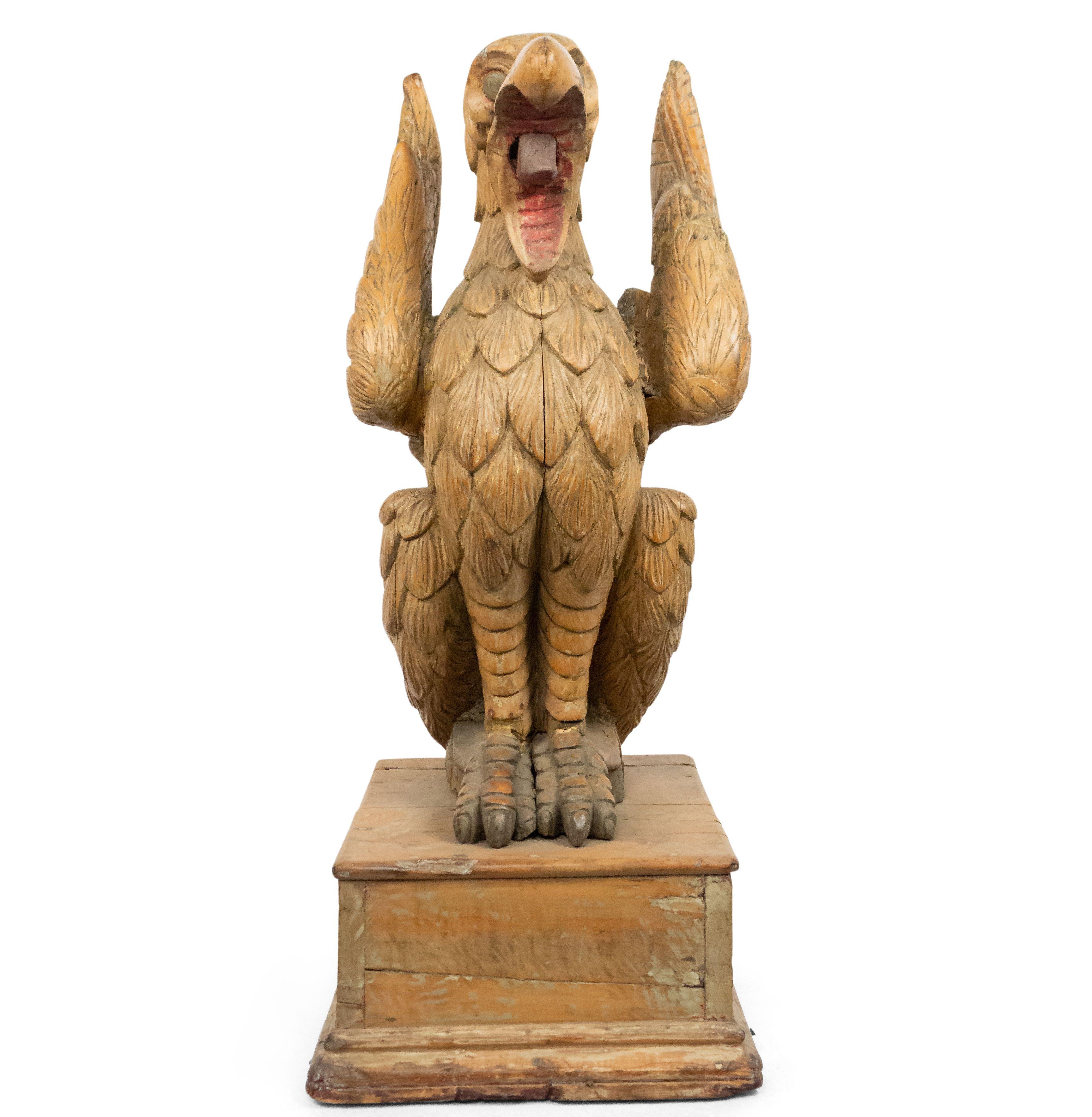 Continental 19th century Dutch life-sized carved wooden eagle figure with open mouth on square pedestal.