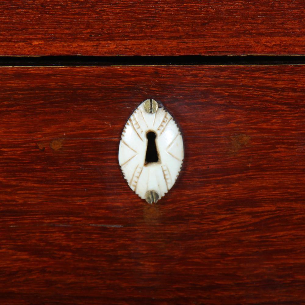 A small Dutch or Dutch-Colonial chest of drawers or 'commode' in padauk, the four graduated drawers with original bone escutcheons, the case of typical Dutch shape with an exaggerated 'bombe' silhouette at the base.

 