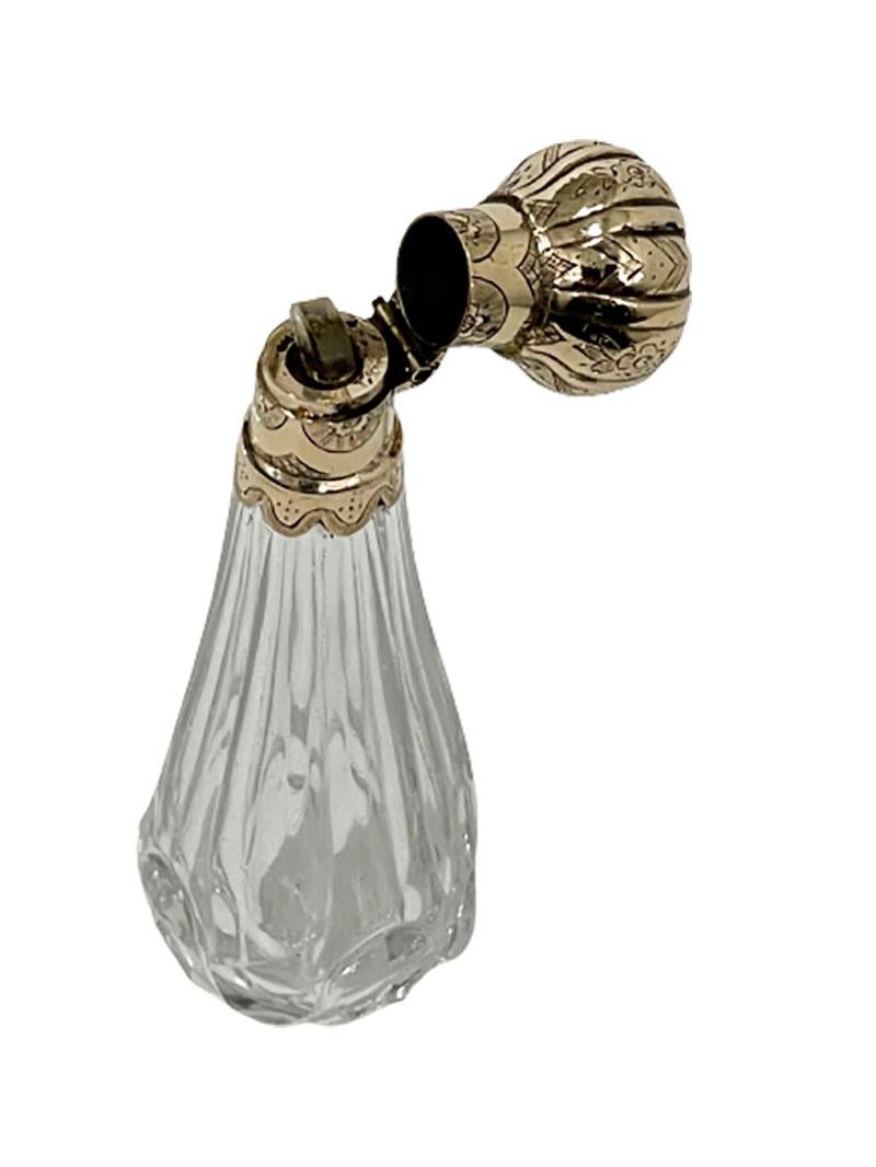 19th century Dutch crystal and gold scent- or perfume bottle

A Dutch golden perfume bottle with an octagonal cut crystal upper body tapering round downwards with Biedermeier engraved tilting cap and neck decoration in 14 karat gold, ca