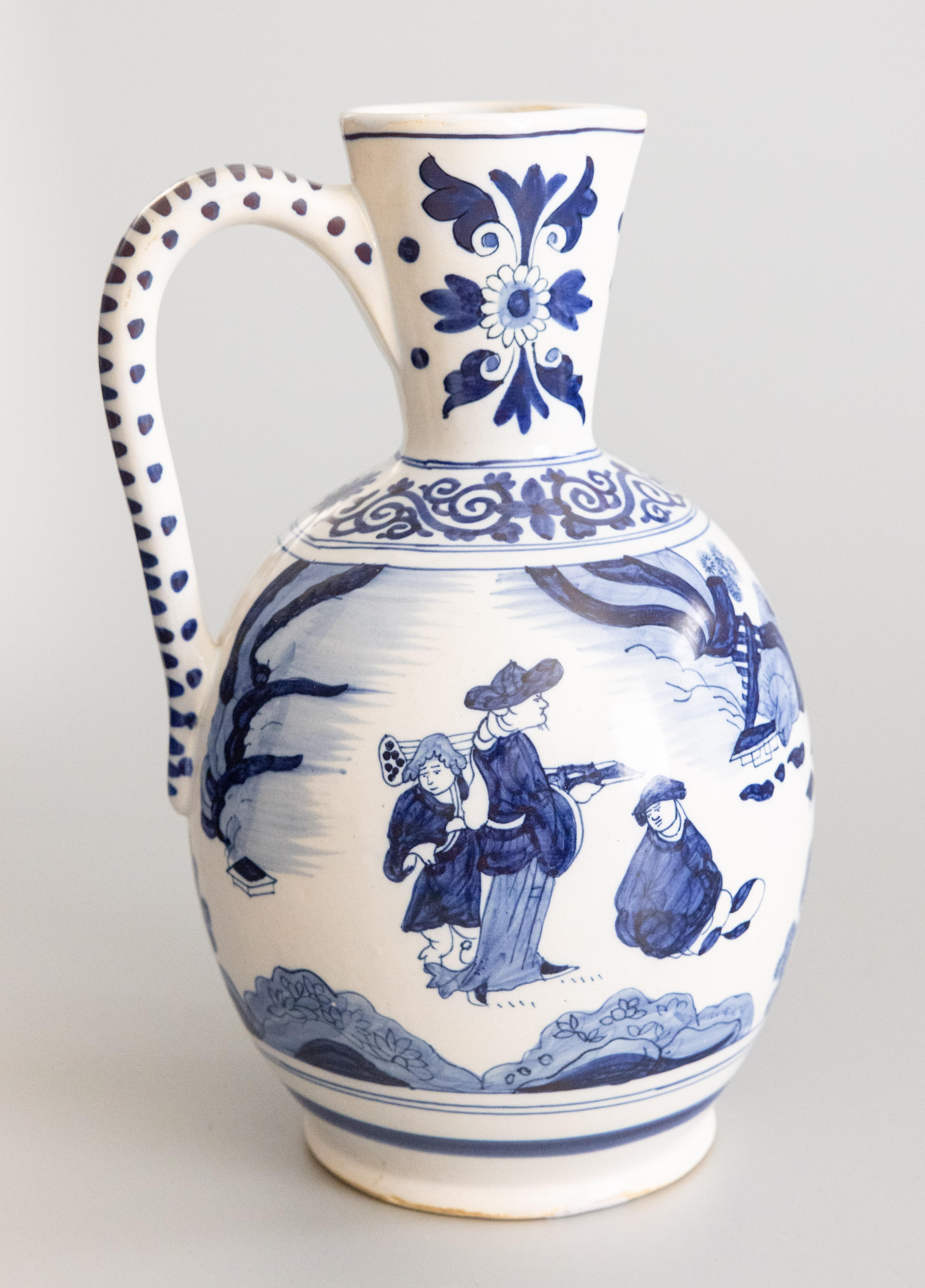 A superb large antique Delft faience cobalt blue and white lobed pitcher made by Boch Frères Keramis in La Louvière, Belgium, circa 1880. This gorgeous wine jug or ewer is decorated with fine hand painted figures, flowers, and landscape in a