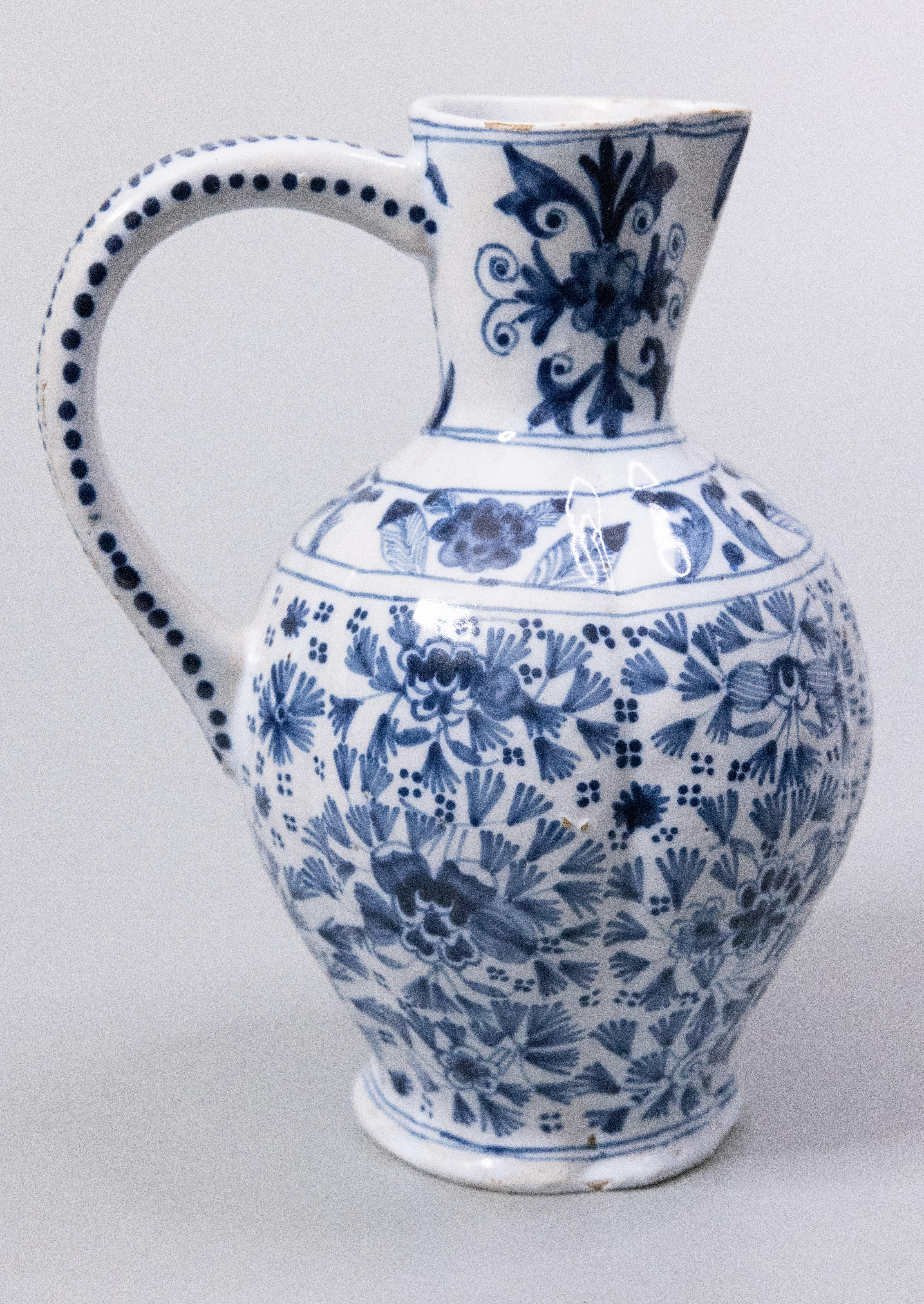 A superb antique 19th-Century Delft faience floral cobalt blue and white pitcher. Signed on the reverse. This gorgeous wine jug or ewer has a wonderful lobed shape with fine hand painted leaves and flowers. It would be lovely with a bouquet of