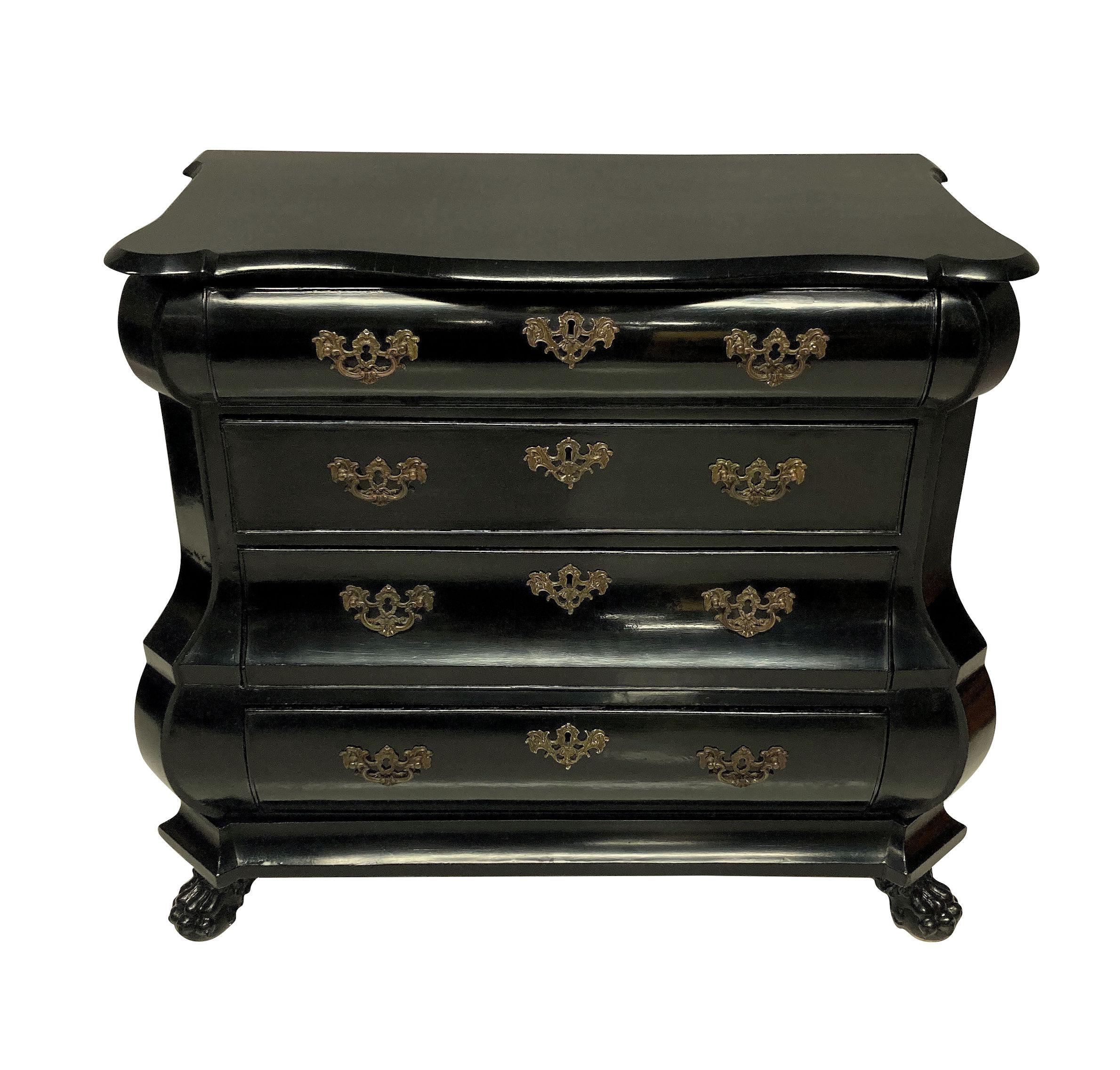 An early XIX century Dutch chest of drawers in ebonised walnut, with the original handles on four drawers and resting on paw feet.