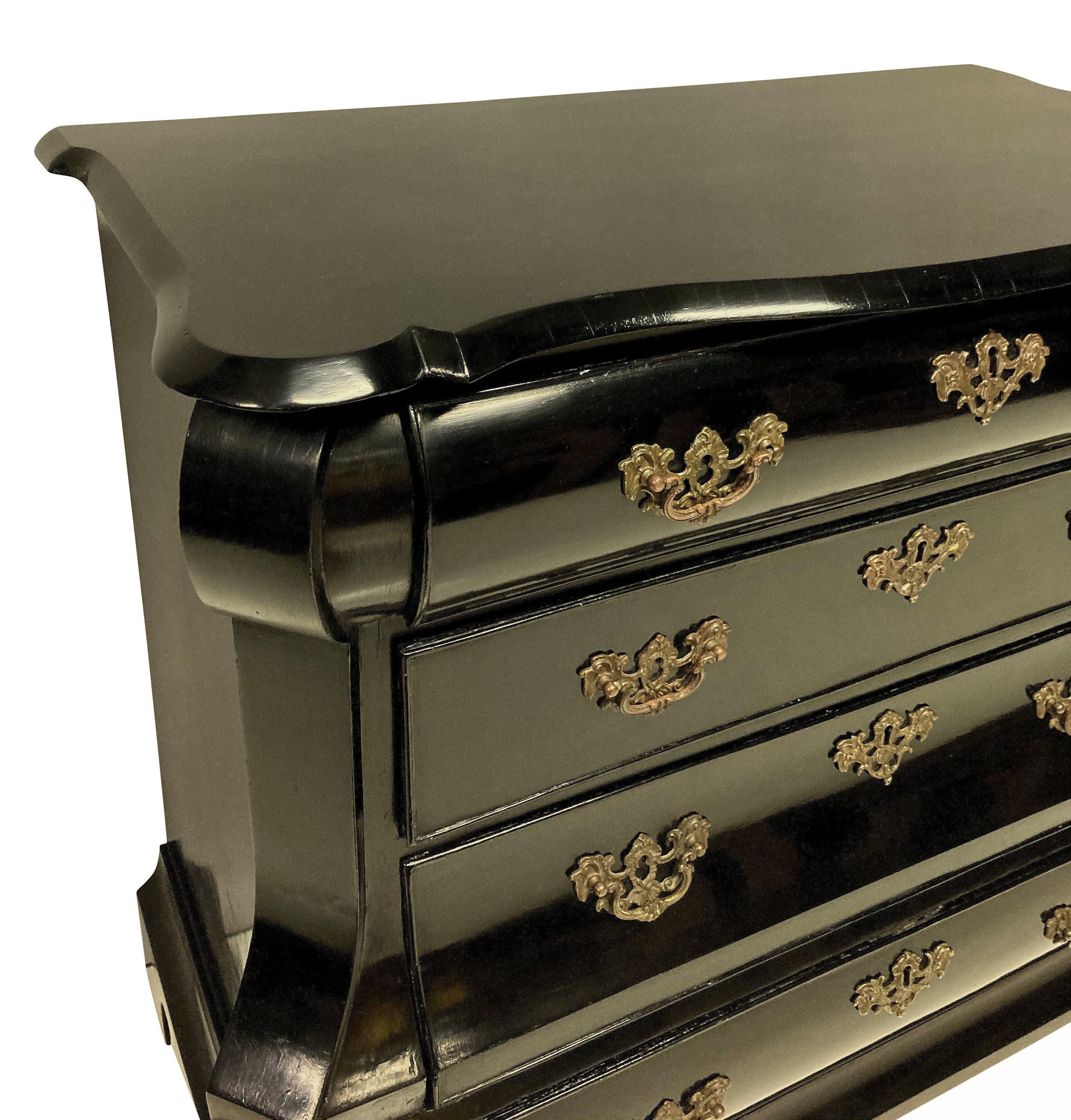 An early XIX century Dutch chest of drawers in ebonised walnut, with the original handles on four drawers and resting on paw feet.
